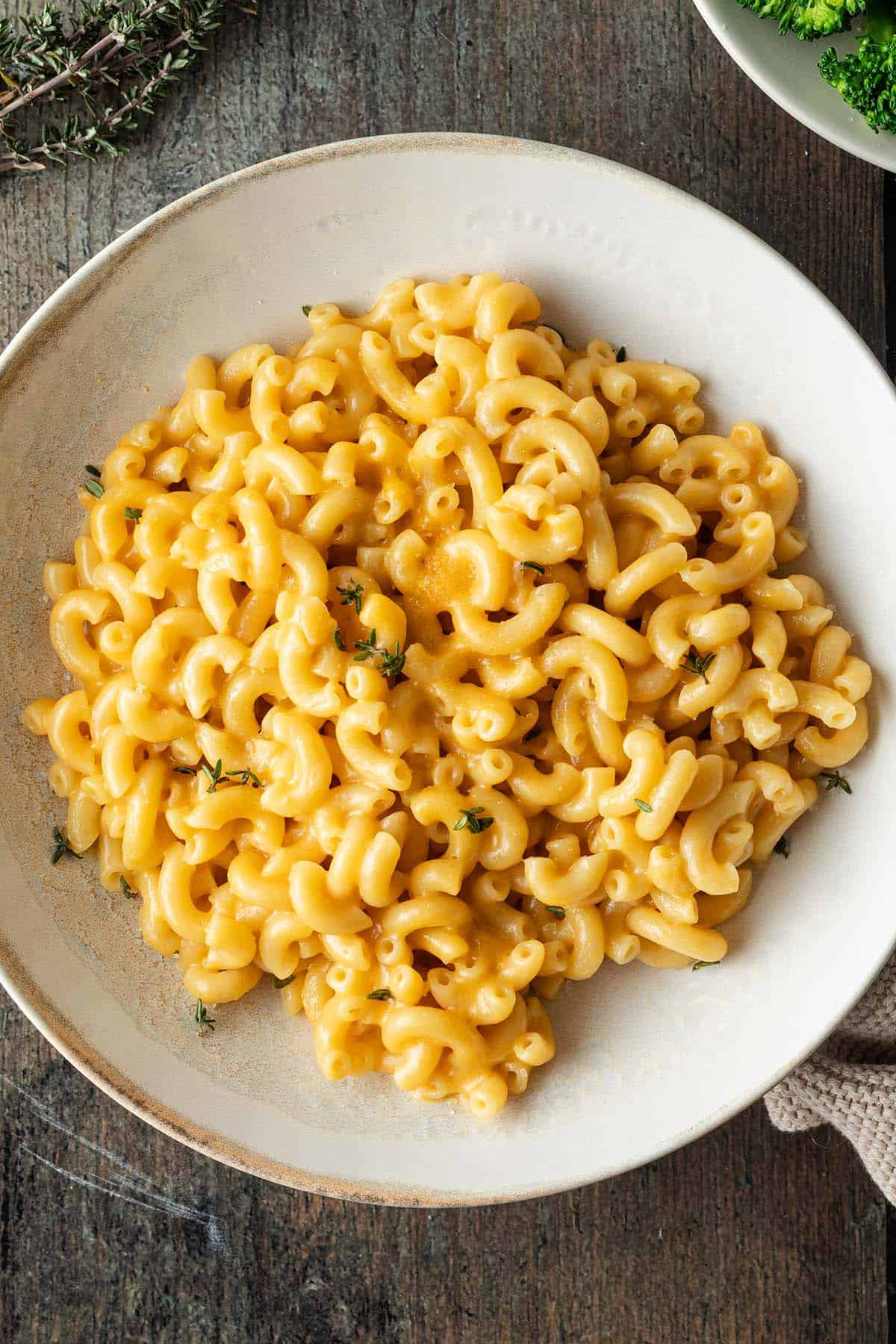 Ein Teller Mac and Cheese auf dunklem Holzuntergrund.