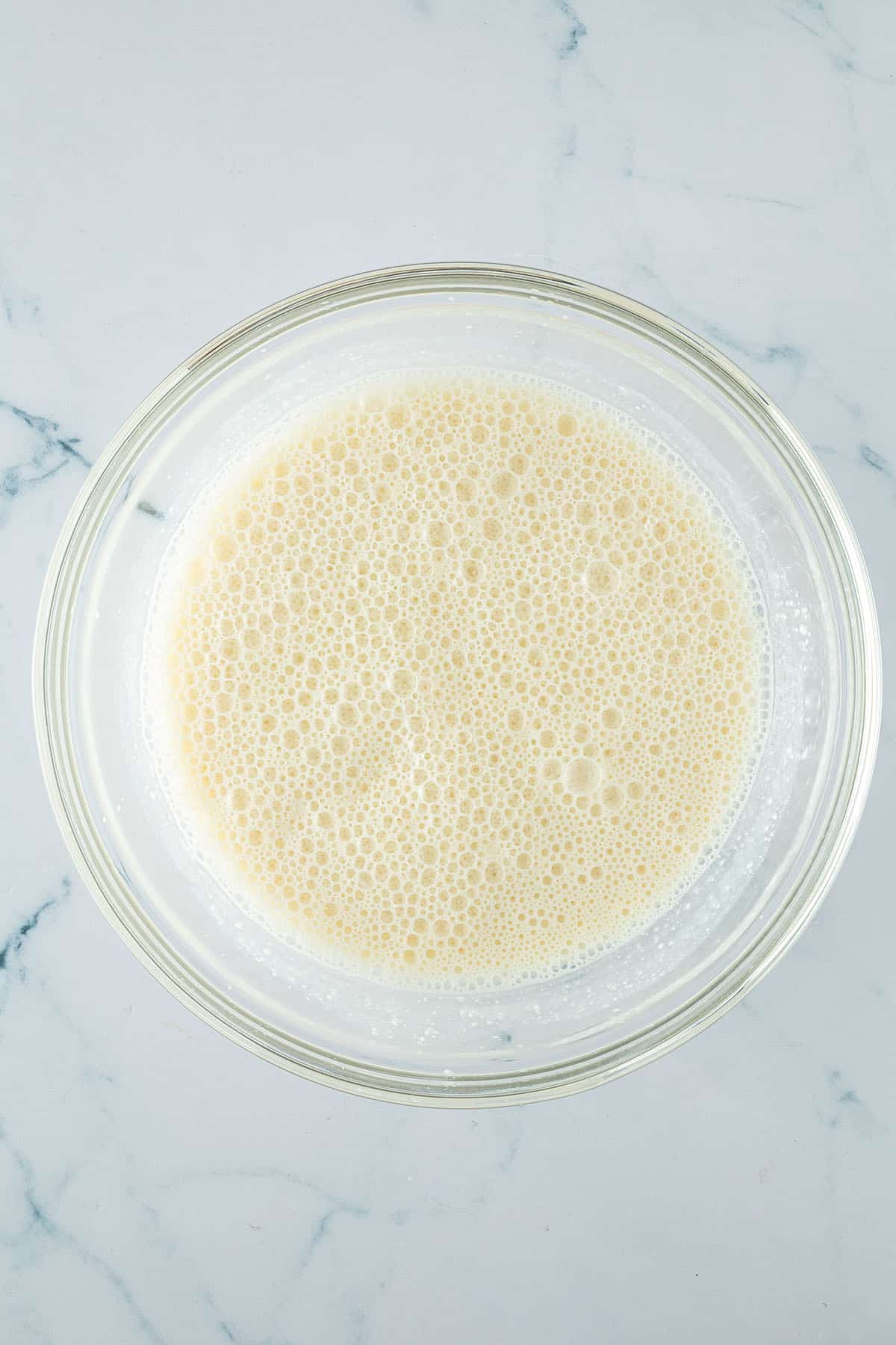 Glas-R&uuml;hrsch&uuml;ssel mit einer hellen, schaumigen Fl&uuml;ssigmasse aus Eiern, Sojamilch und H&uuml;ttenk&auml;se.