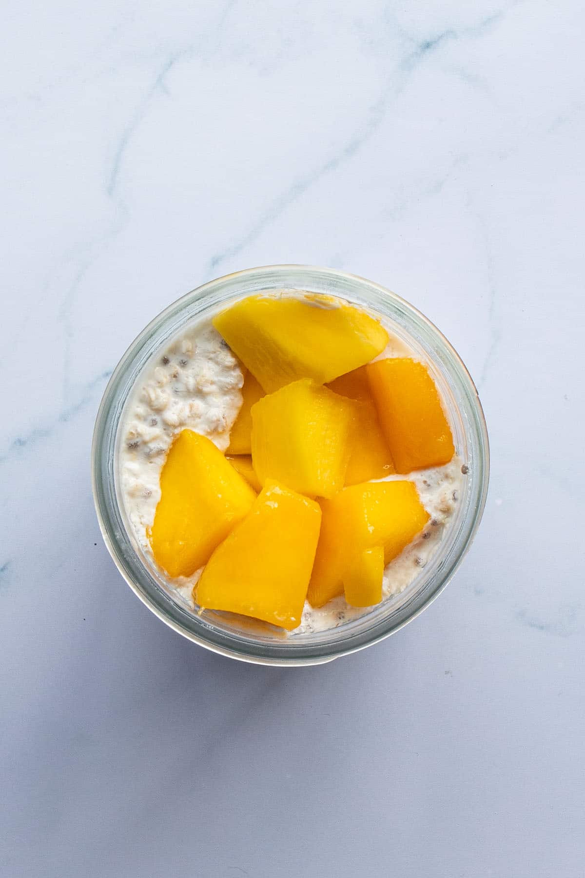 Mango Overnight Oats am n&auml;chsten Morgen mit aufgetauten Mangost&uuml;ckchen.