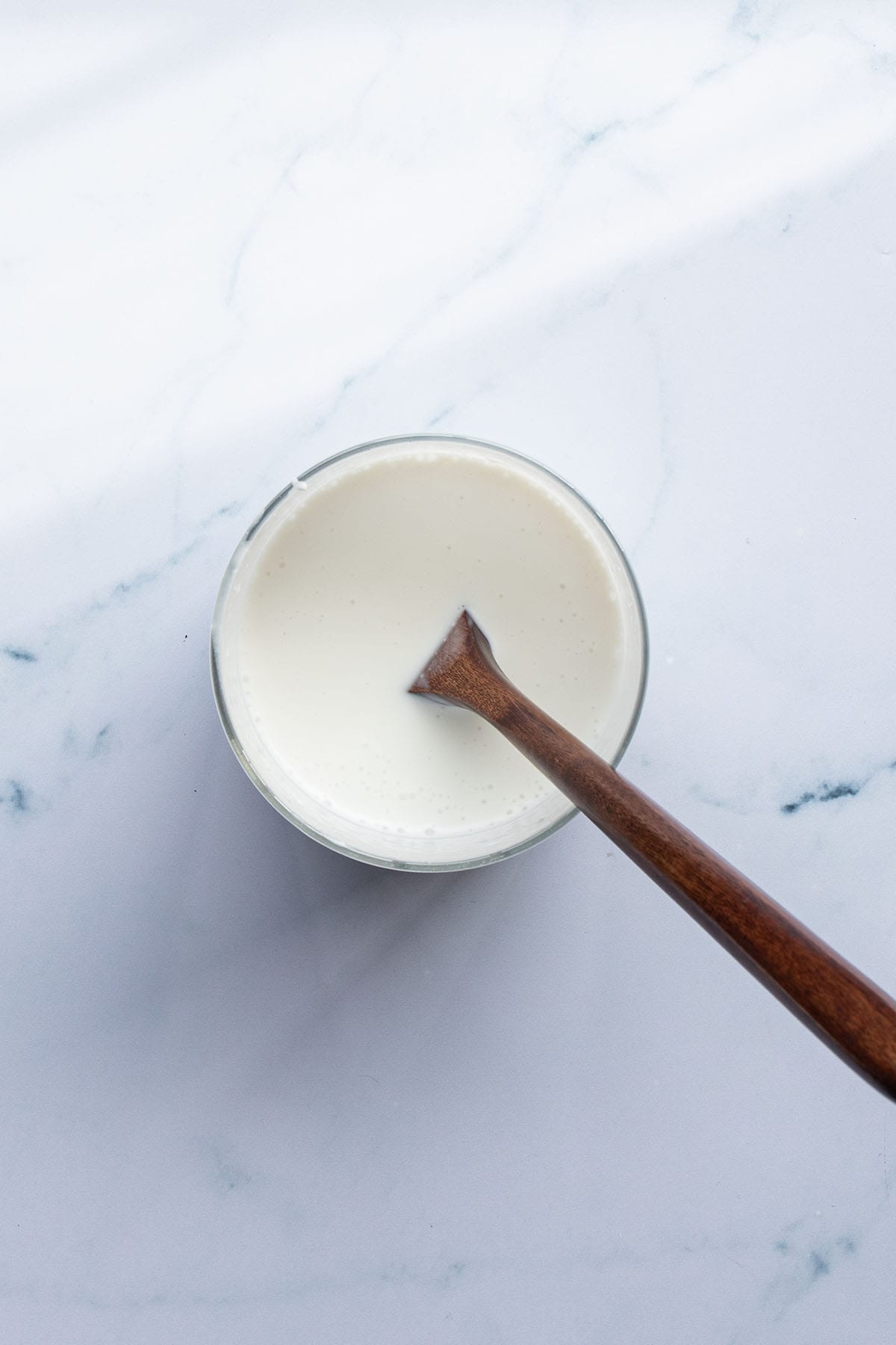 Joghurt, Milch und Kokosmilch wurden in einem Glas verr&uuml;hrt.