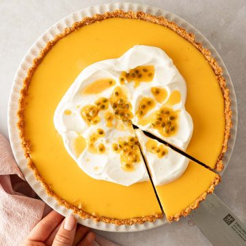 Eine Maracuja Tarte wurde angeschnitten und es wird ein Pie-St&uuml;ck herausgehoben.