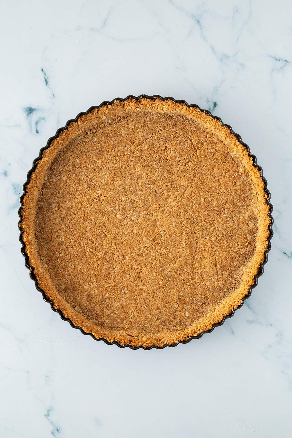 Goldbraun vorgebackener Keksteigboden in einer Tarte-Form.