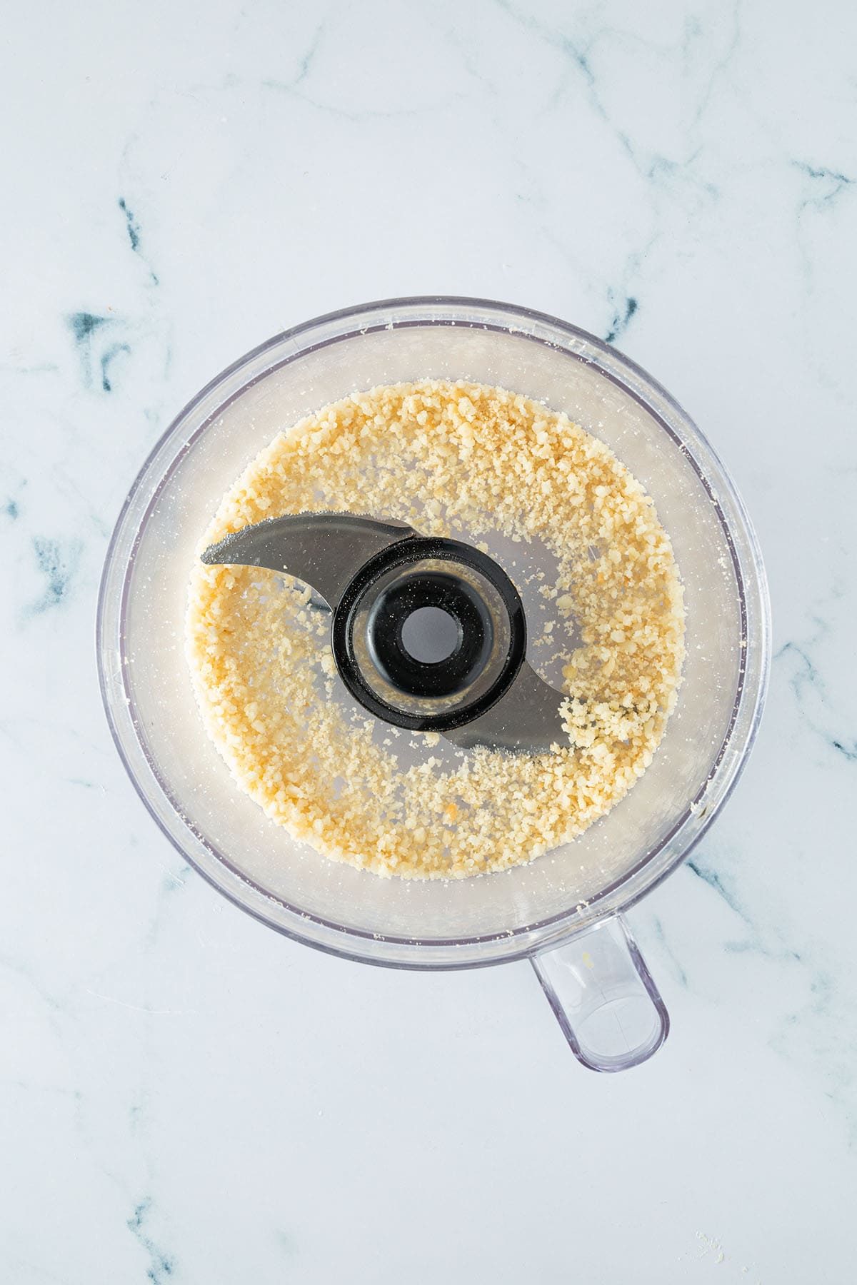 Fein zerkleinere Macadamia-N&uuml;sse in einem Food Processor.