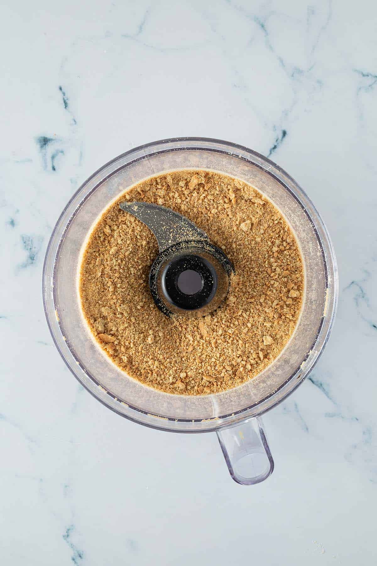 Zu einem feinen Mehl zerkleinerte Butterkekse in einem Food Processor.