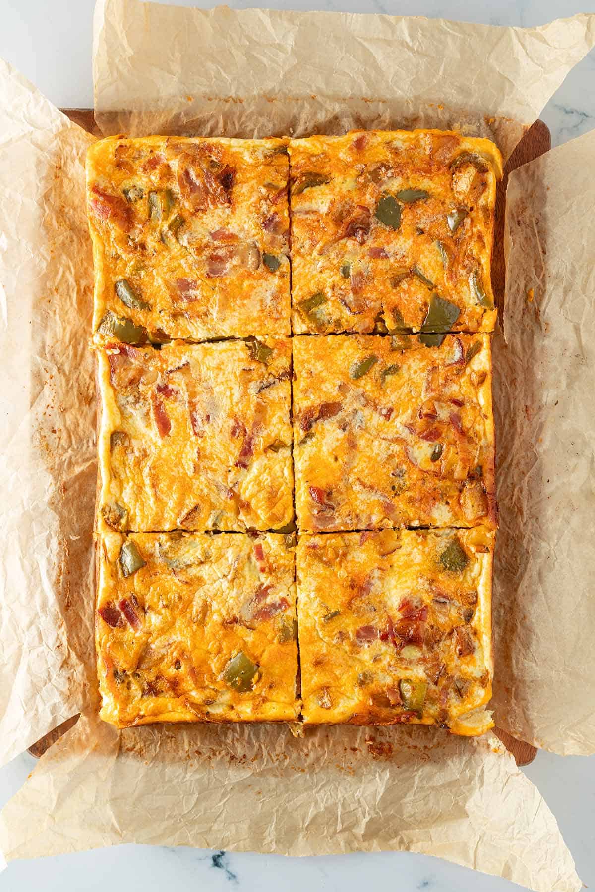 Gro&szlig;es, Gebackene Ofen-Omelett mit Paprika, Kartoffeln und Speck in sechs gleichm&auml;&szlig;ige Quadrate geschnitten.