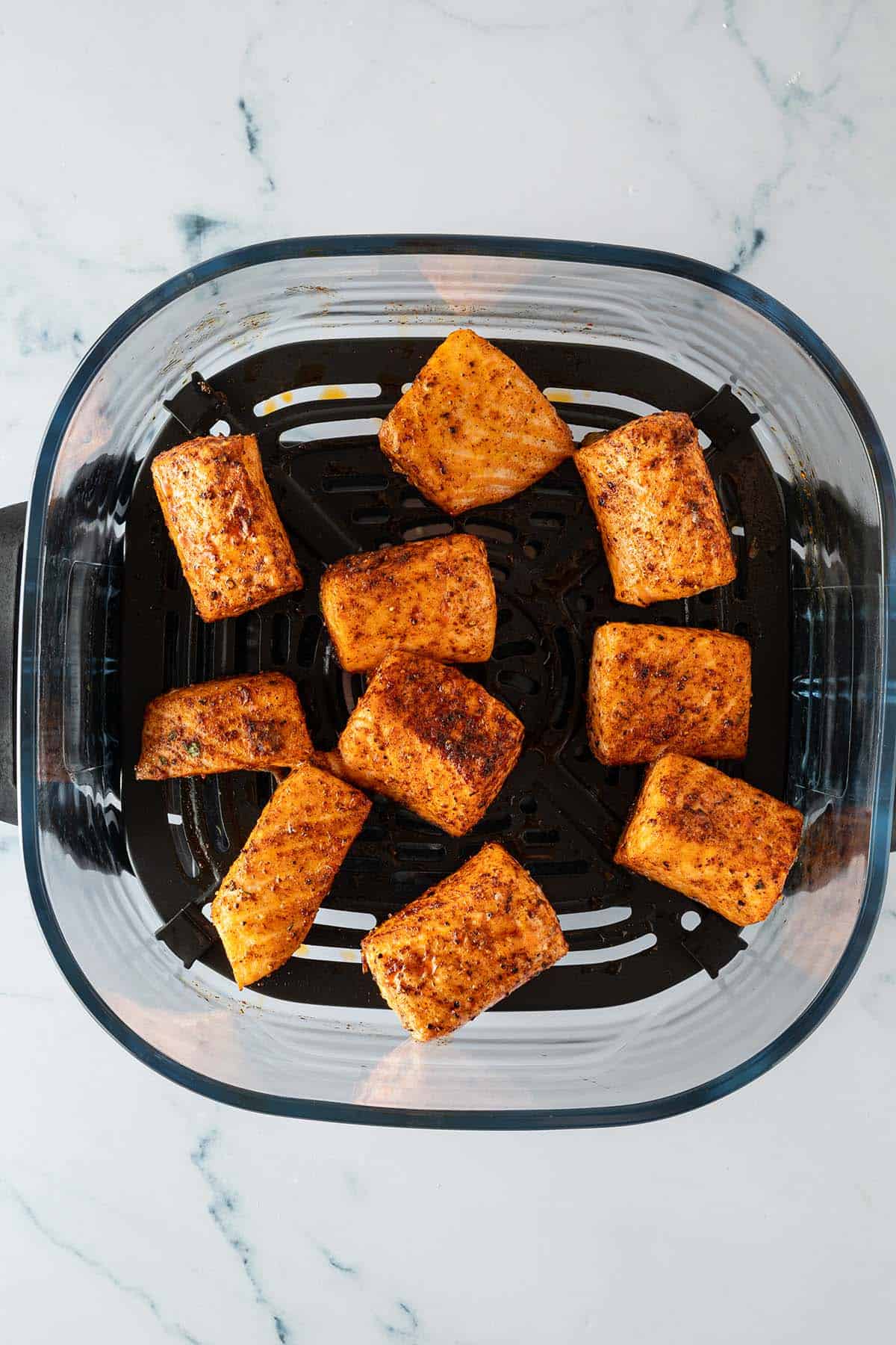 Fertig gegarte Lachsw&uuml;rfel im Airfryer-Korb.