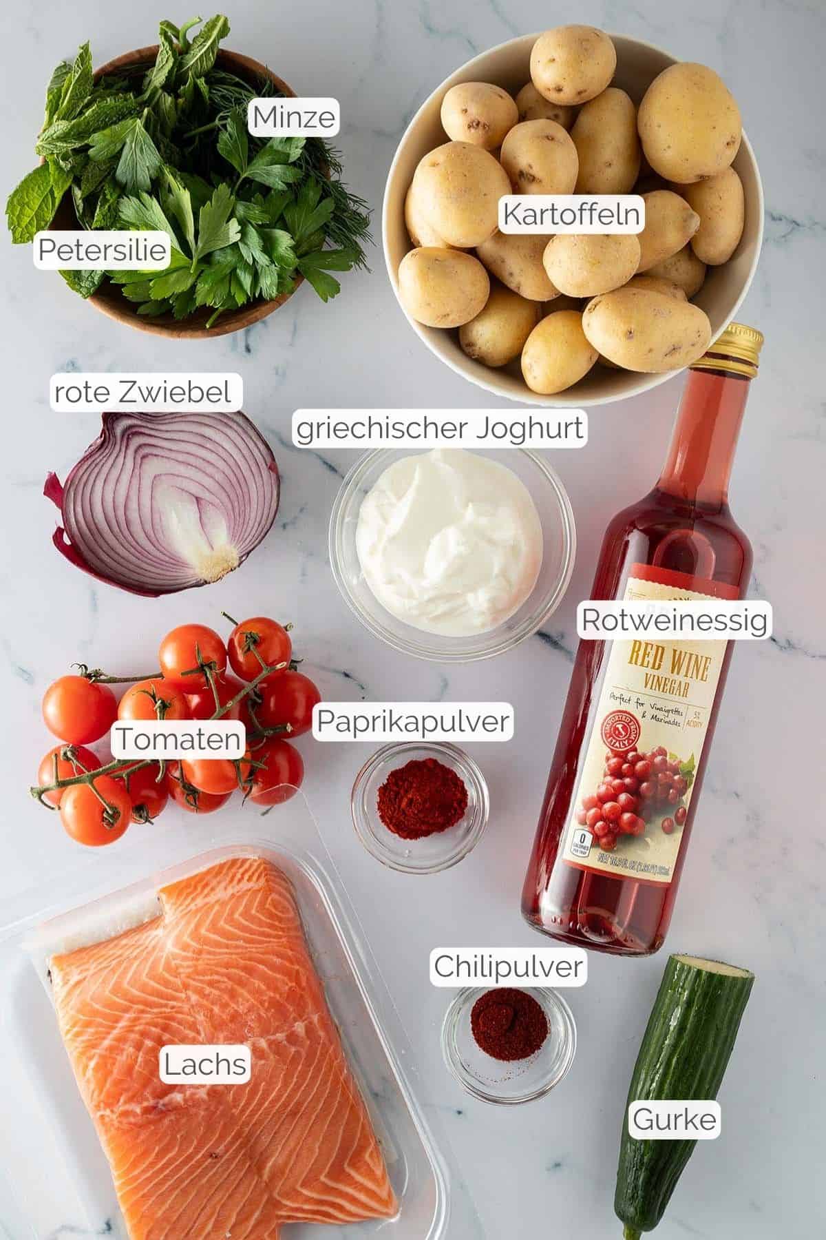 Alle Zutaten mit jeweiligen Textbeschriftungen, die f&uuml;r die mediterrane Lachs Bowl ben&ouml;tigt werden.