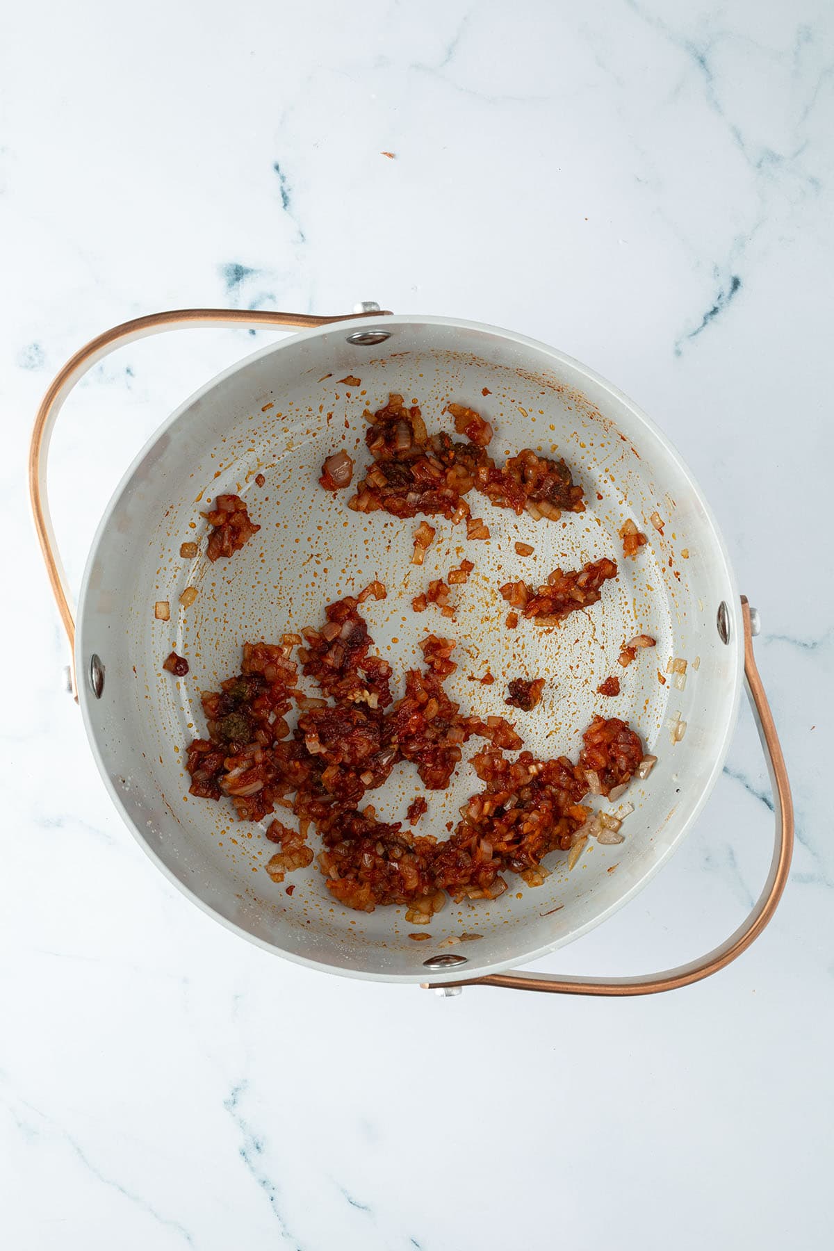 Schalotten, Gochujang, und Ingwer werden in einem Topf angebraten.
