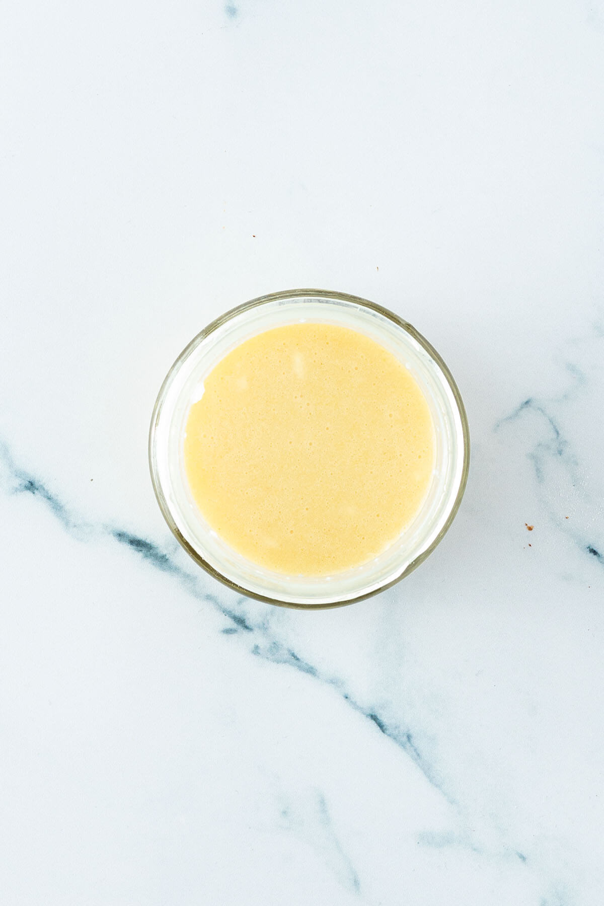 Cremiges, hellgelbes Nizza Dressing in einem Glas.