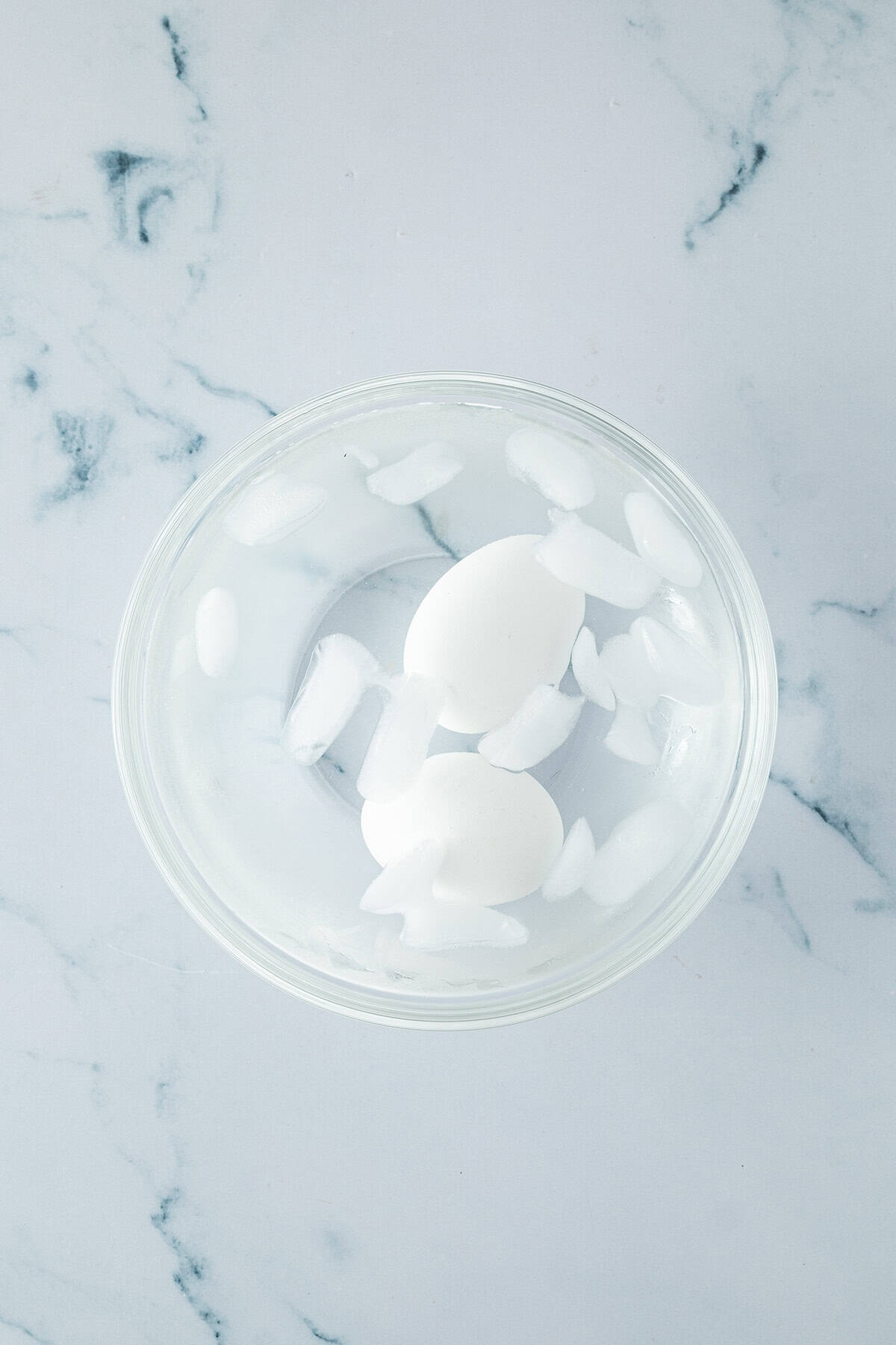 Zwei Eier in einem Schüssel mit Wasser und Eiswürfeln.