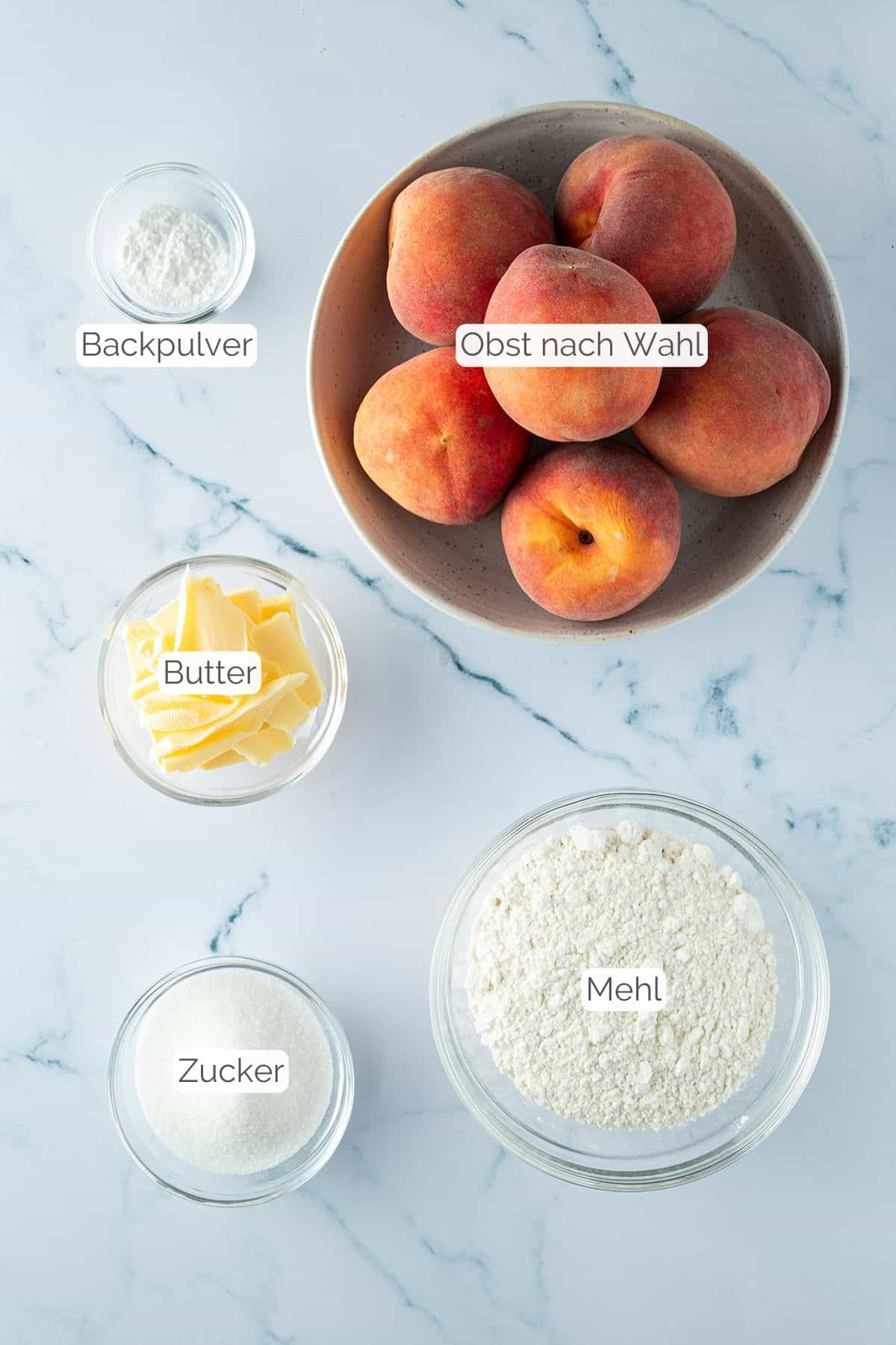 Alle Zutaten mit Textbeschriftungen, die f&uuml;r den Obst Crumble ben&ouml;tigt werden.