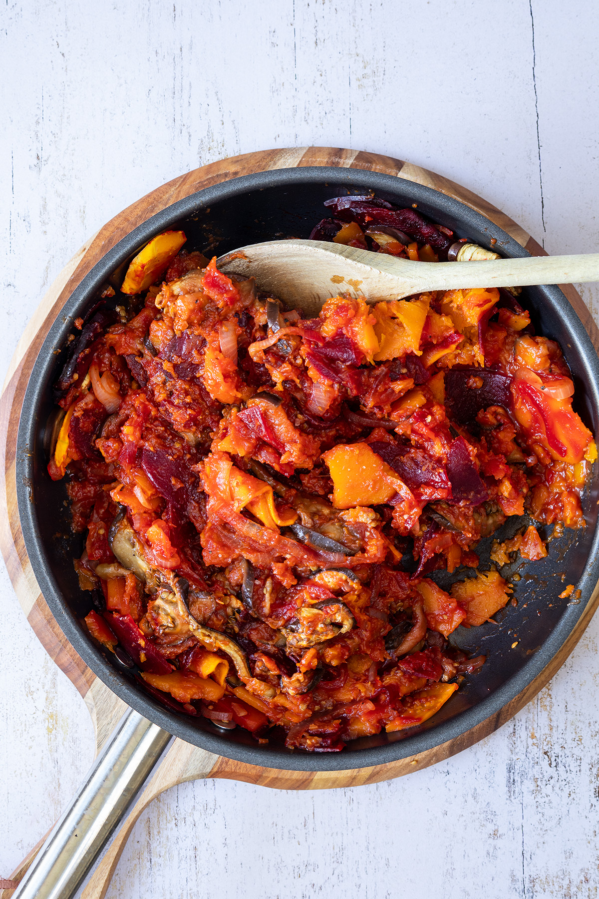 Im Ofen weich gegartes K&uuml;rbisgem&uuml;se wird in einer Pfanne mit Pesto und passierten Tomaten verfeinert.