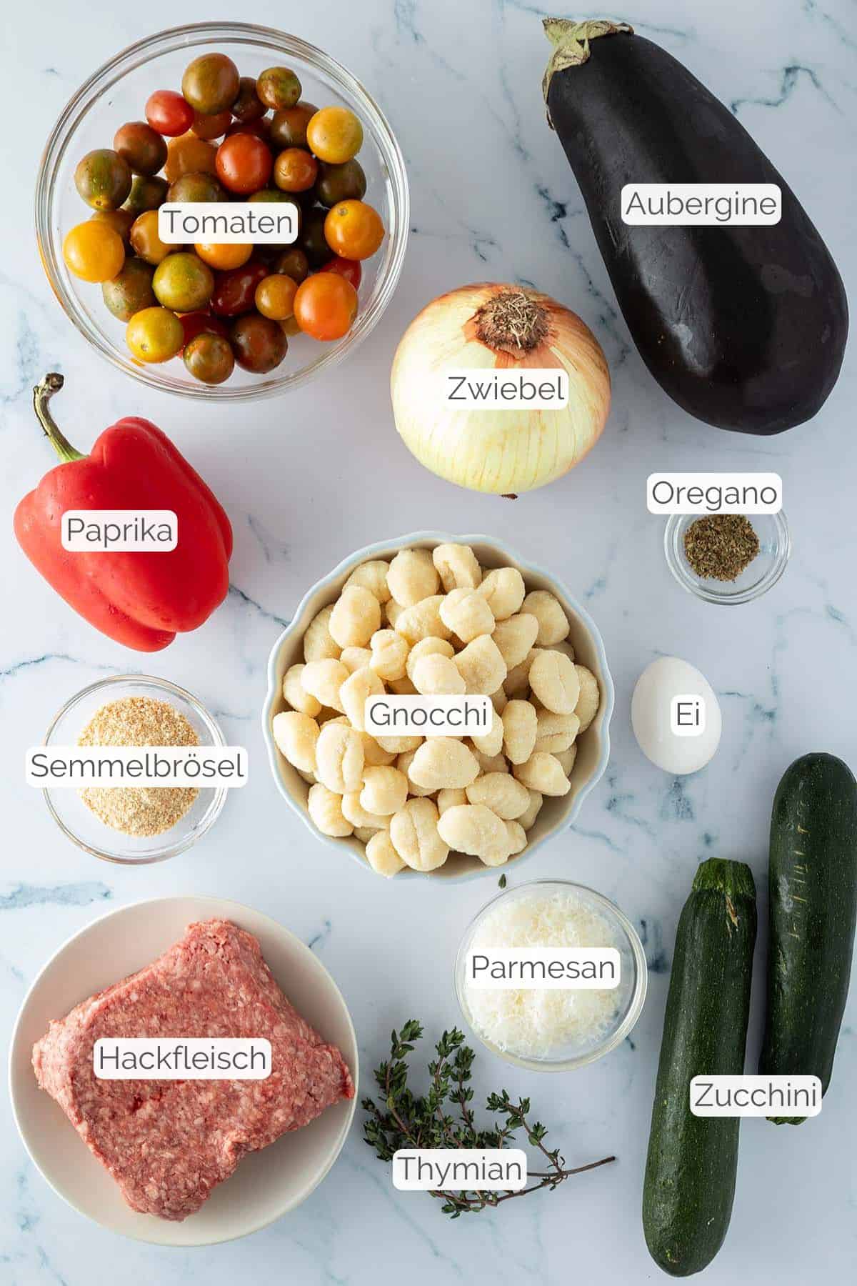 Alle Zutaten mit jeweiligen Textbeschriftungen, die f&uuml;r das Ofen Ratatouille Rezept mit Gnocchi und Hackb&auml;llchen ben&ouml;tigt werden.