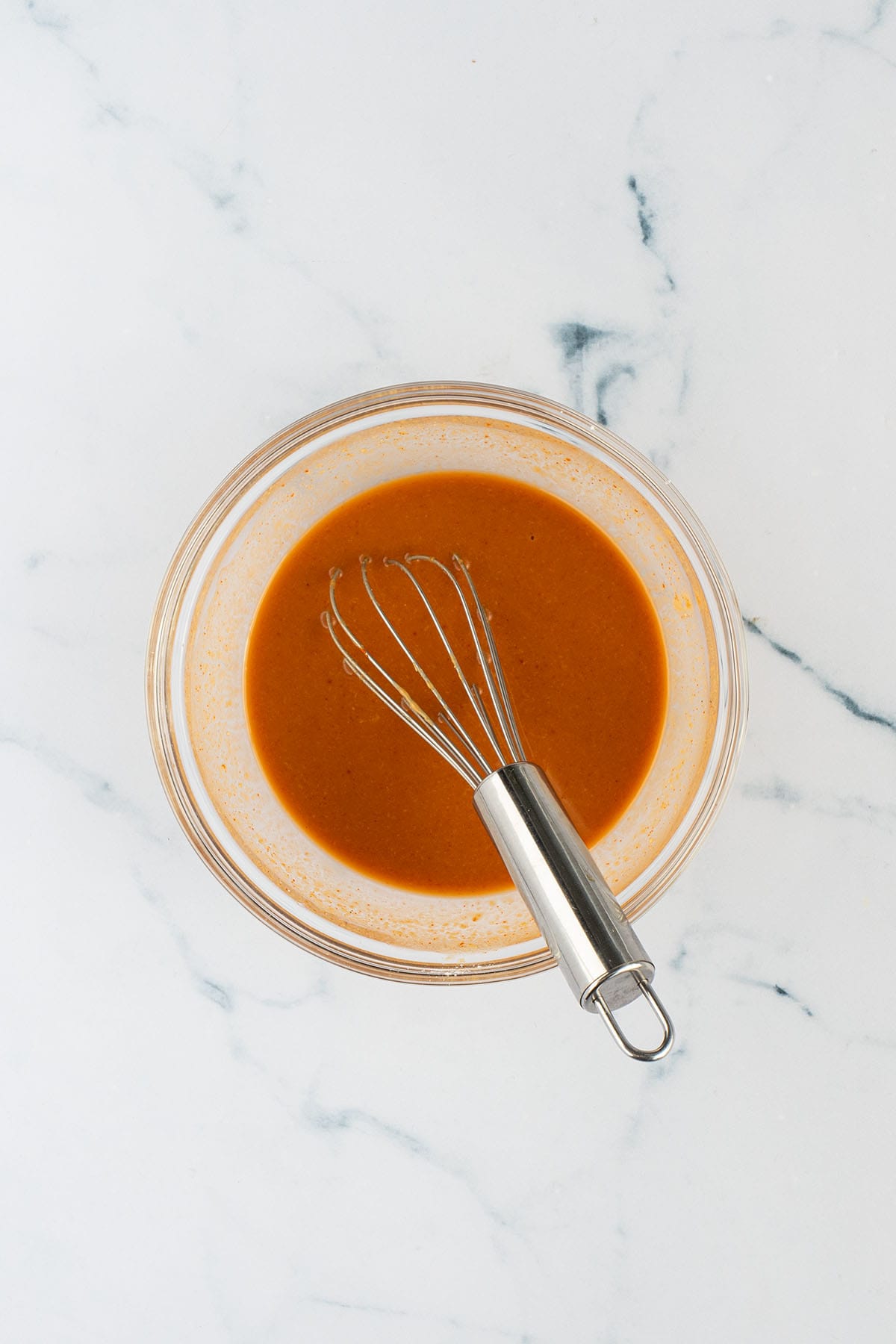 Erdnussbutter-Miso-Sauce in einer Sch&uuml;ssel mit einem Mini-Schneebesen.