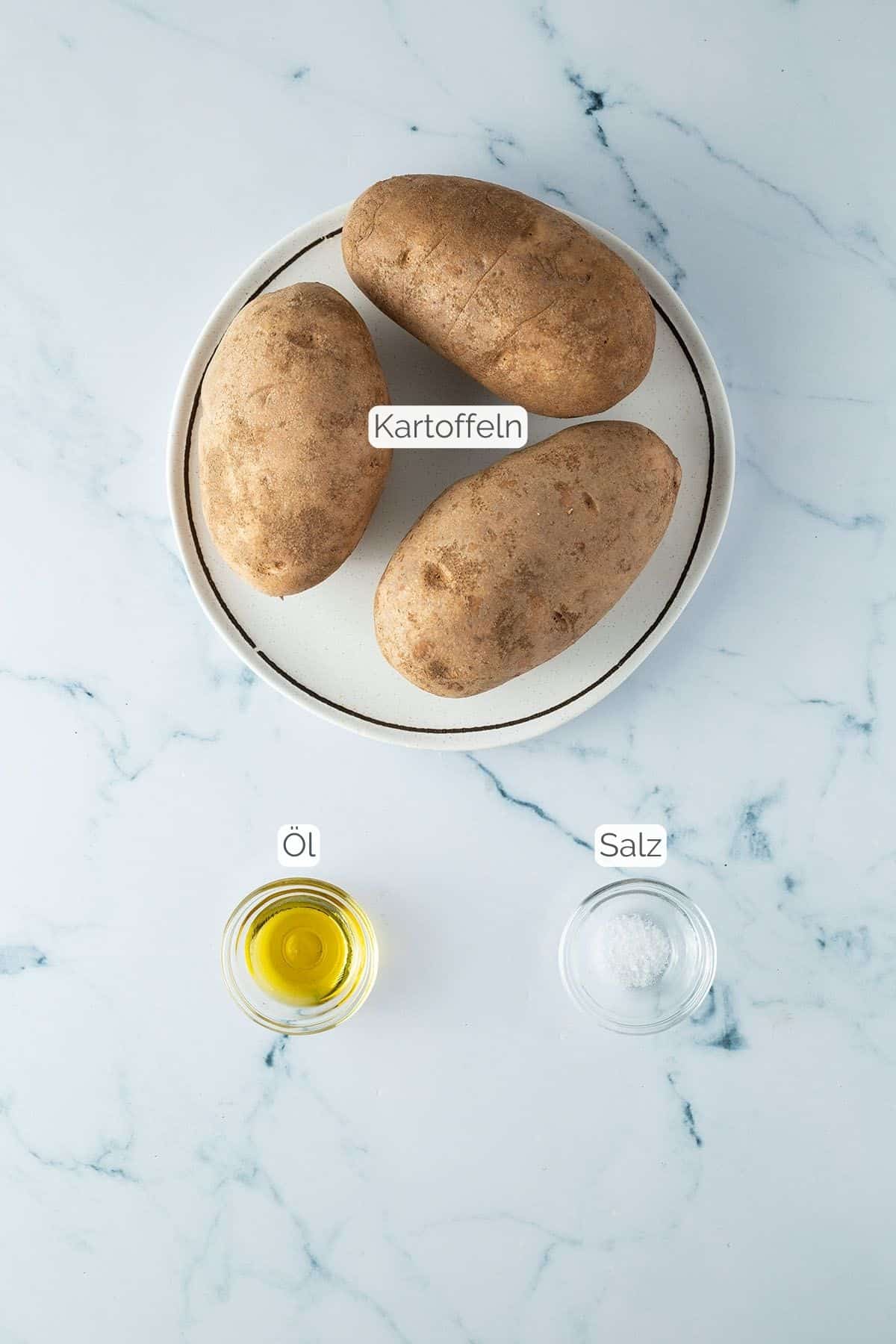 Alle Zutaten mit Textbeschriftungen, die f&uuml;r Ofenkartoffeln aus der Hei&szlig;luftfritteuse ben&ouml;tigt werden.