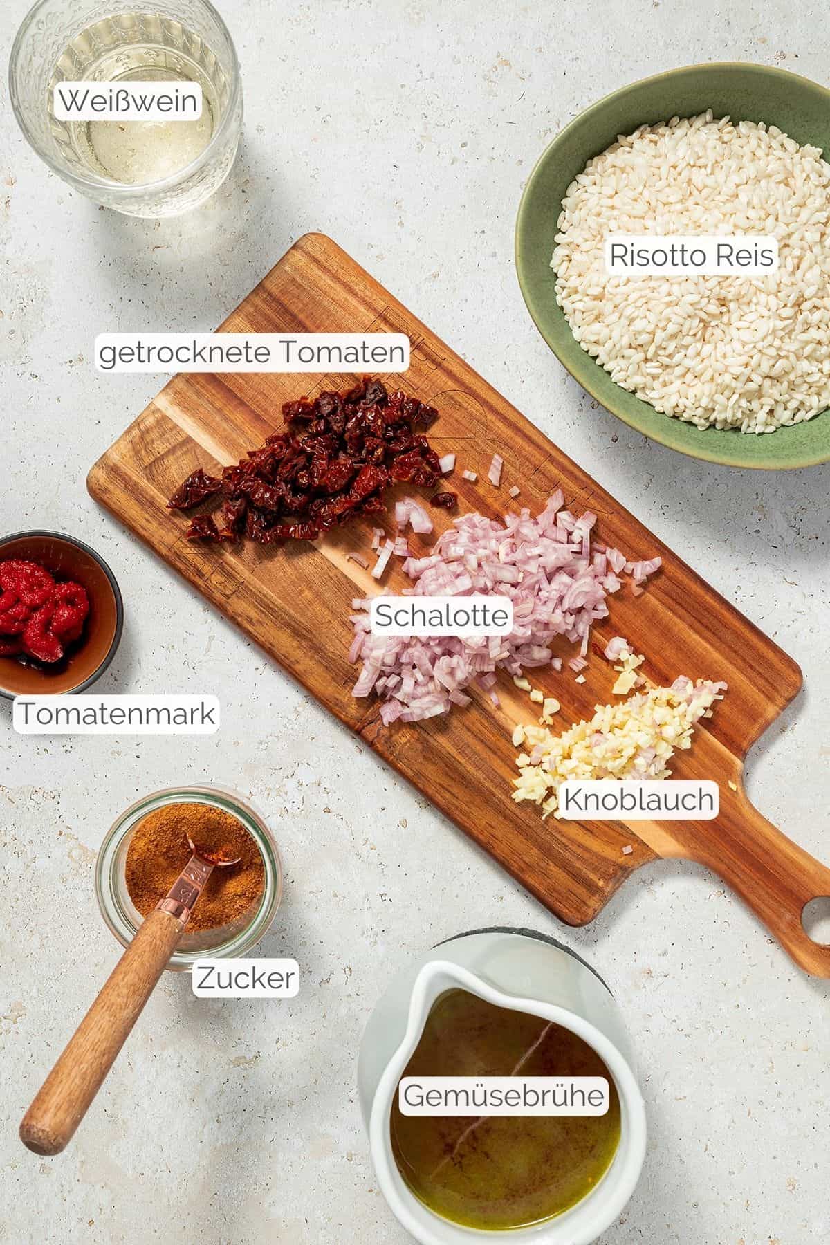 Alle Zutaten f&uuml;r das Tomaten Ofenrisotto mit jeweiligen Textbeschriftungen.