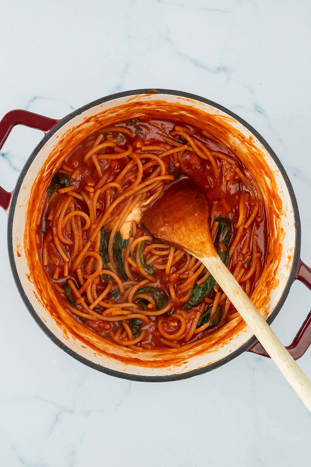 Vogelperspektive auf einen Topf mit einem Spaghetti One Pot mit Tomatensauce, Spinat und Mozzarella.