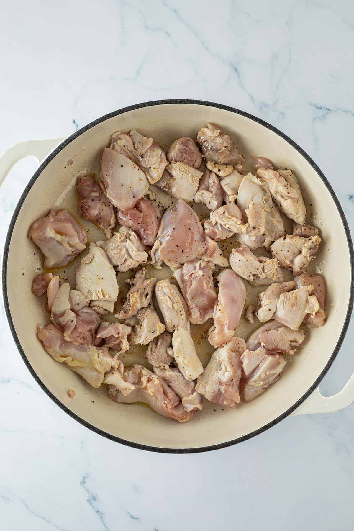 H&auml;hnchenst&uuml;cke beim Anbraten in einer gro&szlig;en Pfanne.
