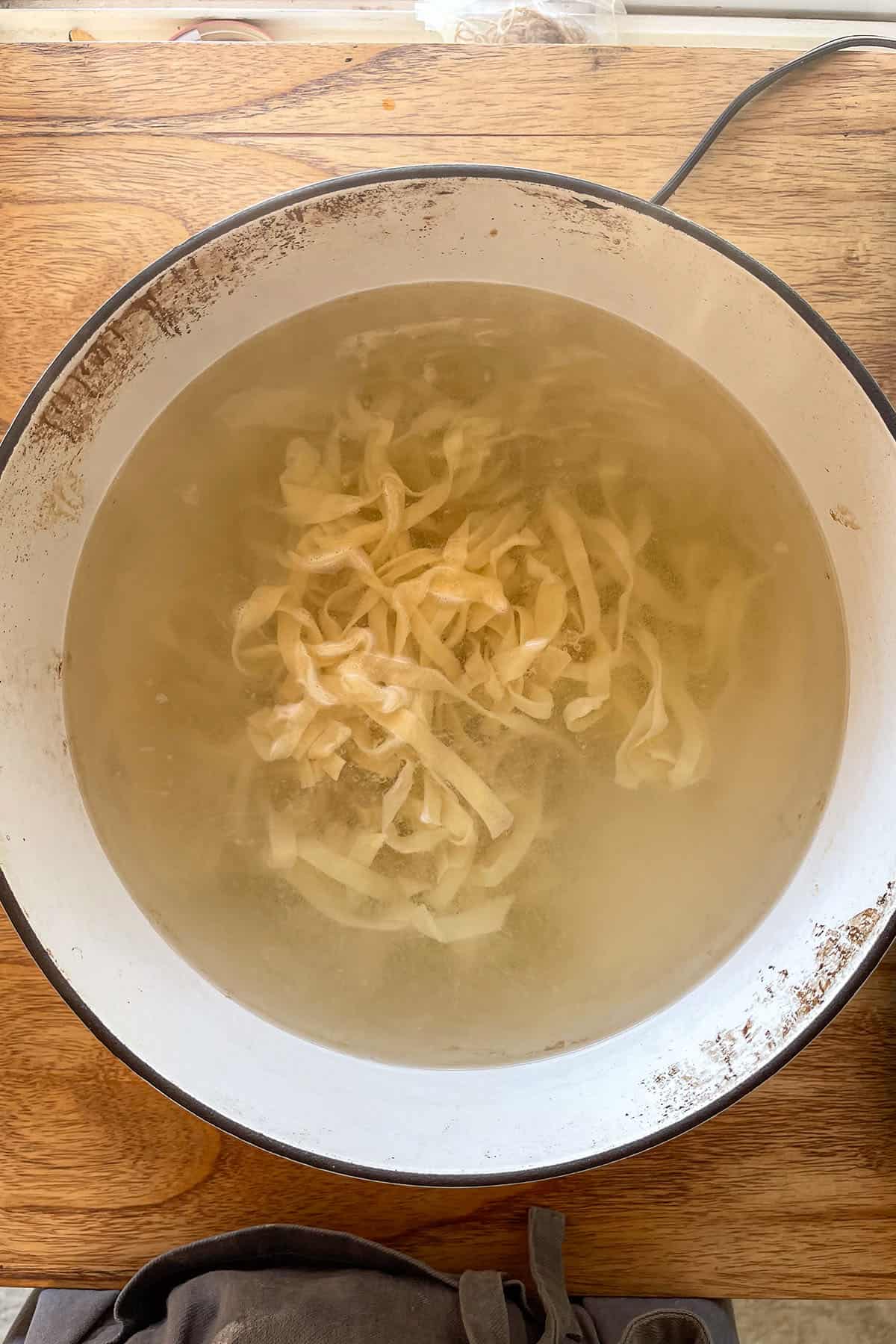Selbstgemachte Bandnudeln werden in einem gro&szlig;en Topf mit kochendem Salzwasser gekocht.