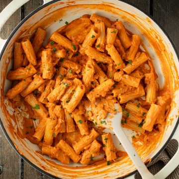 Penne alla Vodka in einer gro&szlig;en Pfanne auf Holzuntergrund.