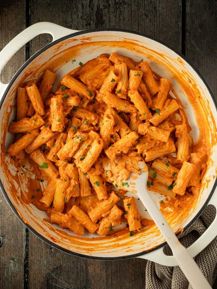 Penne alla Vodka in einer gro&szlig;en Pfanne auf Holzuntergrund.
