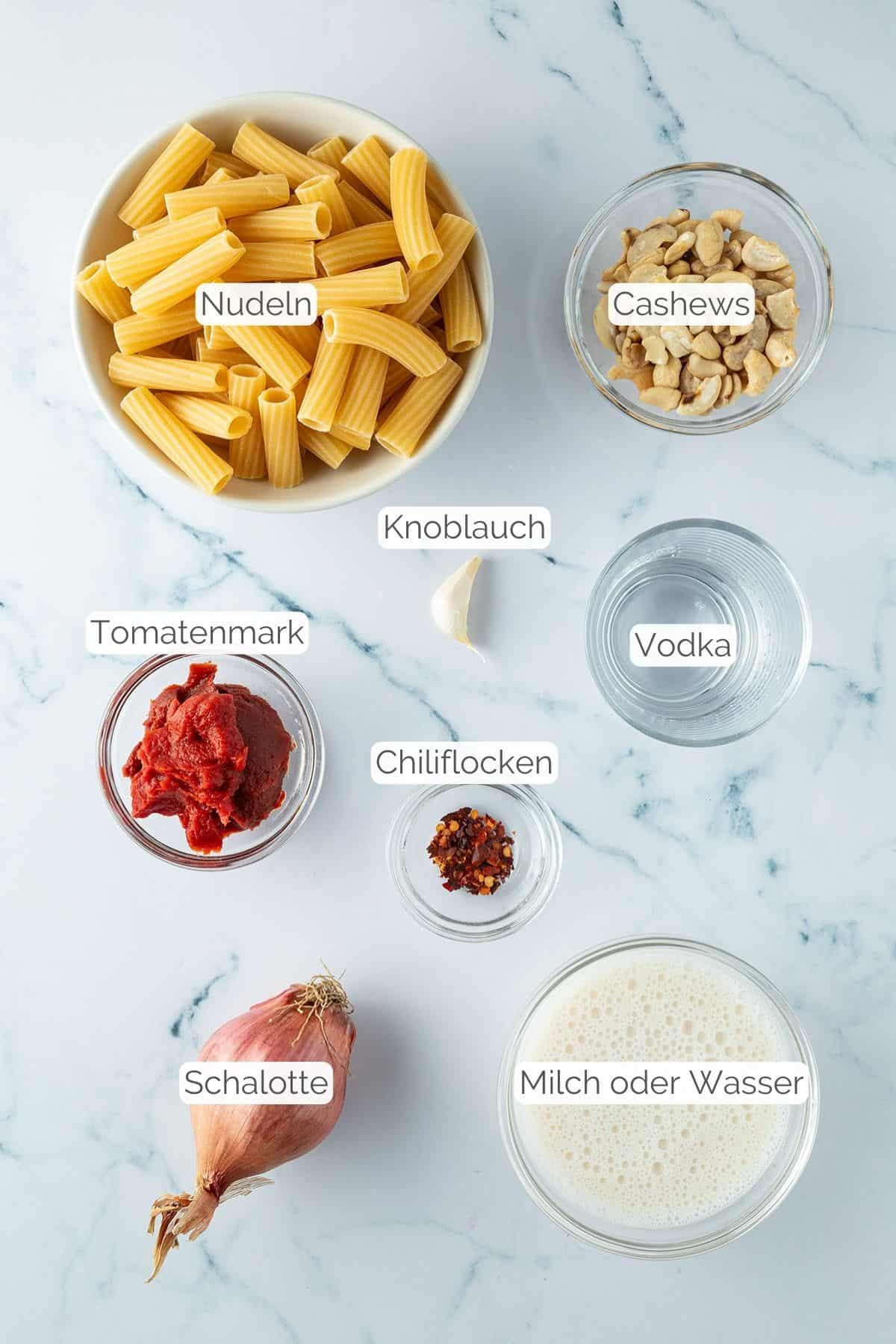 Alle Zutaten mit Textbeschriftungen, die f&uuml;r Penne alla Vodka ben&ouml;tigt werden.