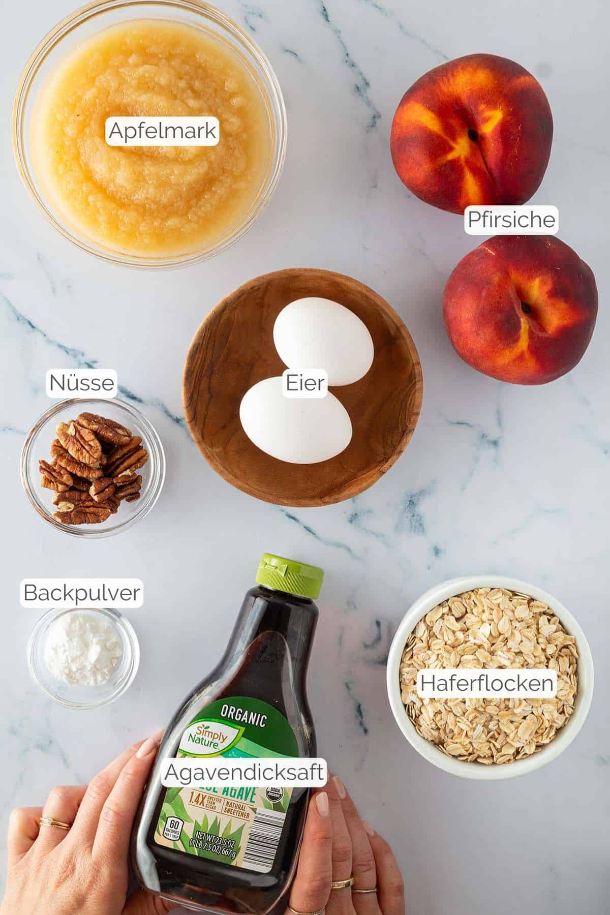 Alle Zutaten mit jeweiligen Textbeschriftungen, die f&uuml;r das sommerliche Pfirsich Baked Oatmeal ben&ouml;tigt werden.