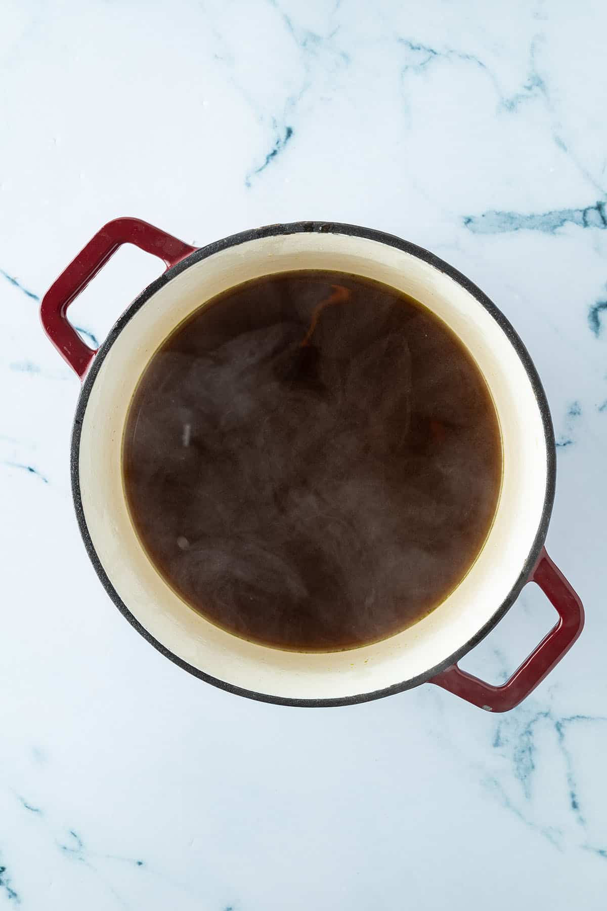 Ein Topf mit der dunklen, klaren Pho Br&uuml;he nach dem Abseihen.