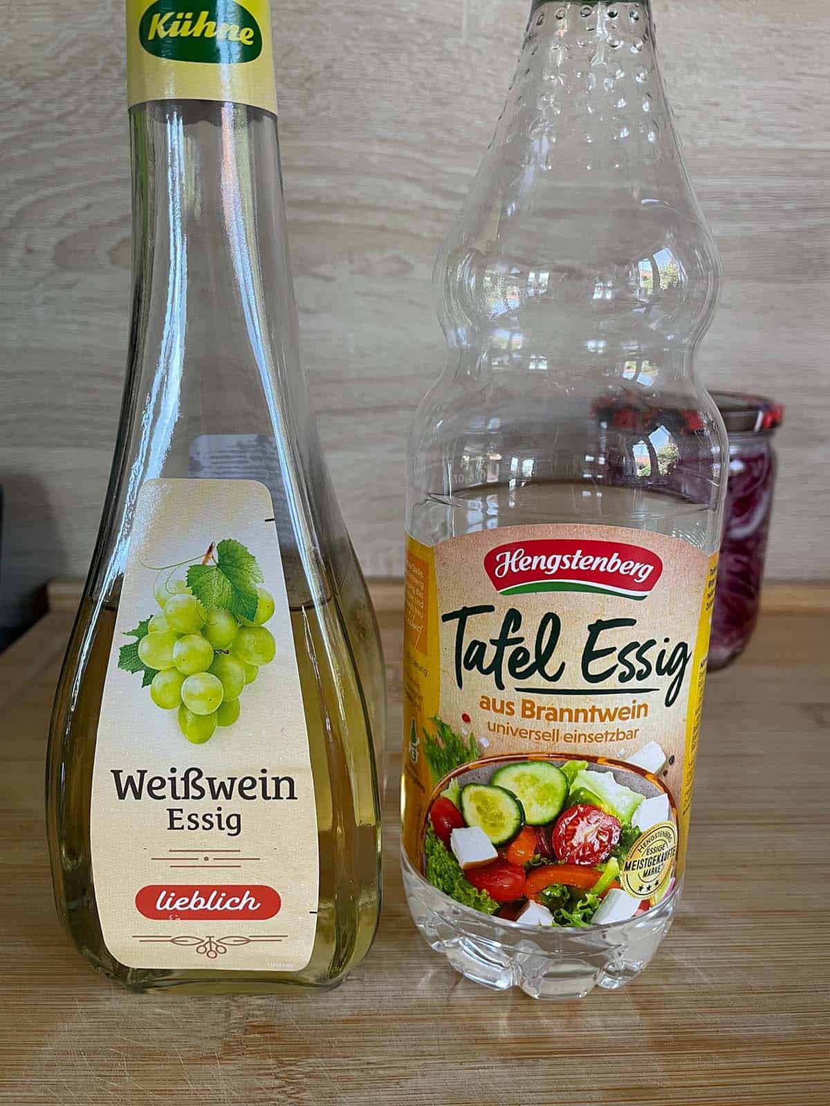 Zwei Flaschen Essig auf einer K&uuml;chentheke.
