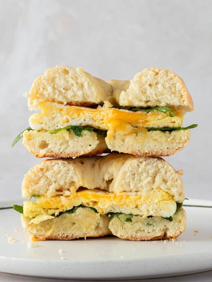 Ein &uuml;bereinander gestapeltes Bagel Sandwich mit Ei und Rucola.