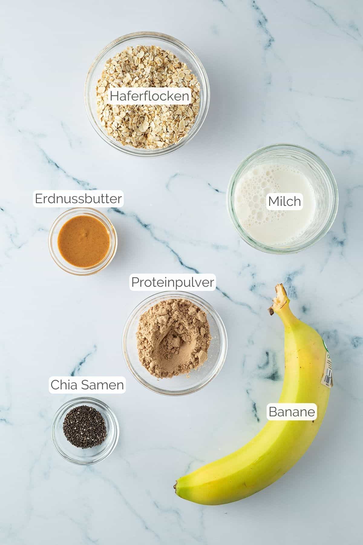 Alle Zutaten mit jeweiligen Textbeschriftungen, die f&uuml;r die Protein Overnight Oats ben&ouml;tigt werden.