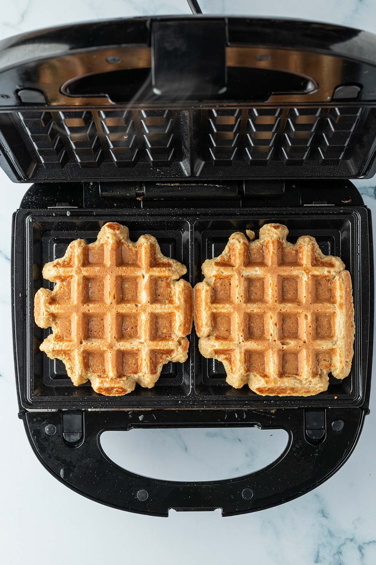 Zwei dicke Waffeln in einem Waffeleisen.