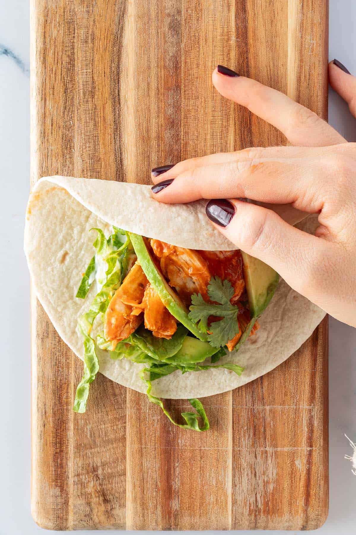 Das obere Ende von einem Tacos wird auf die F&uuml;llung gefaltet.