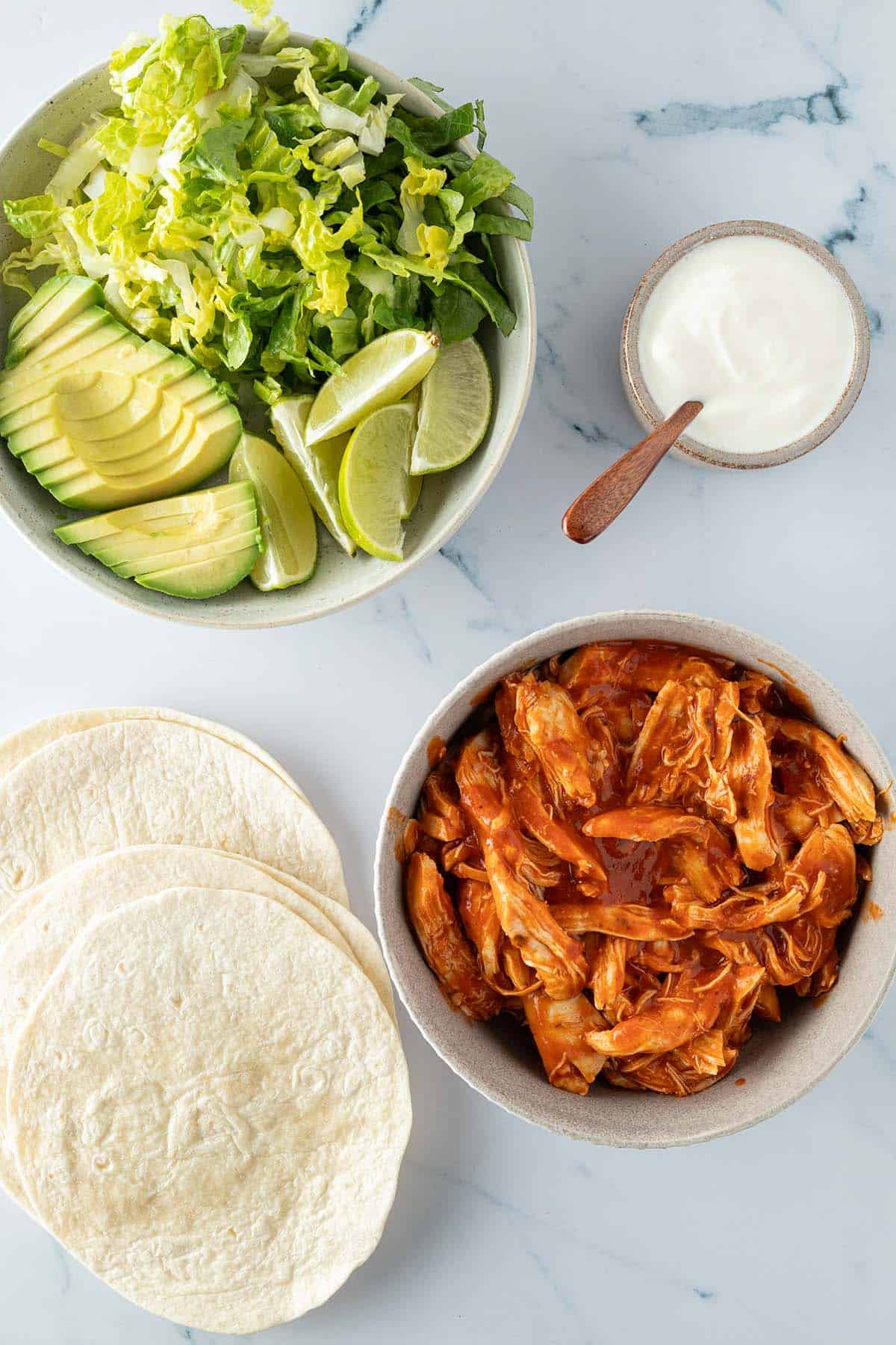 Alle, fertig zubereiteten Komponenten f&uuml;r die Tacos auf einem Marmor-Untergrund.
