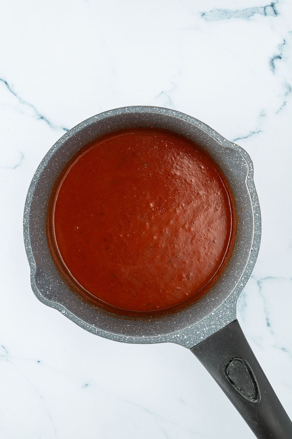 Dickfl&uuml;ssige, rote Sauce in einem Topf.
