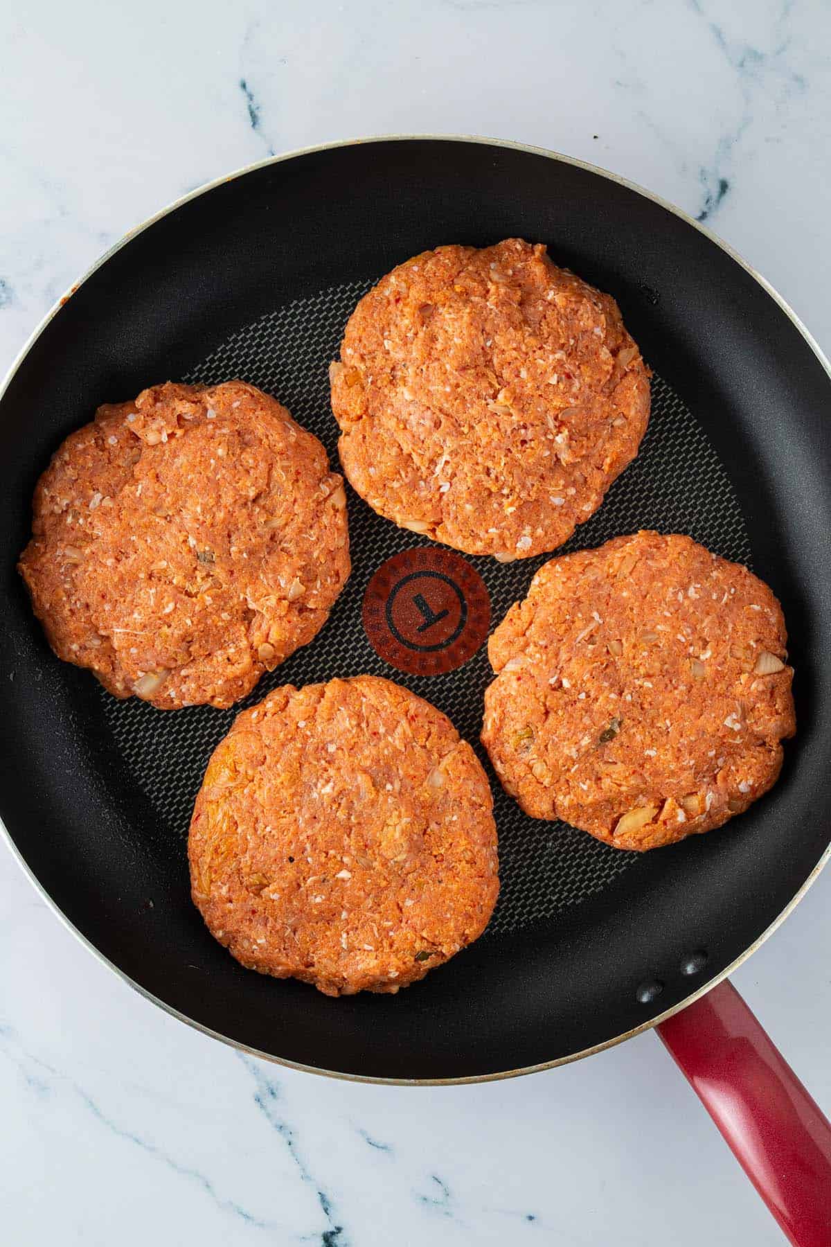 Vier Puten-Kimchi-Burger in einer gro&szlig;en Pfanne.