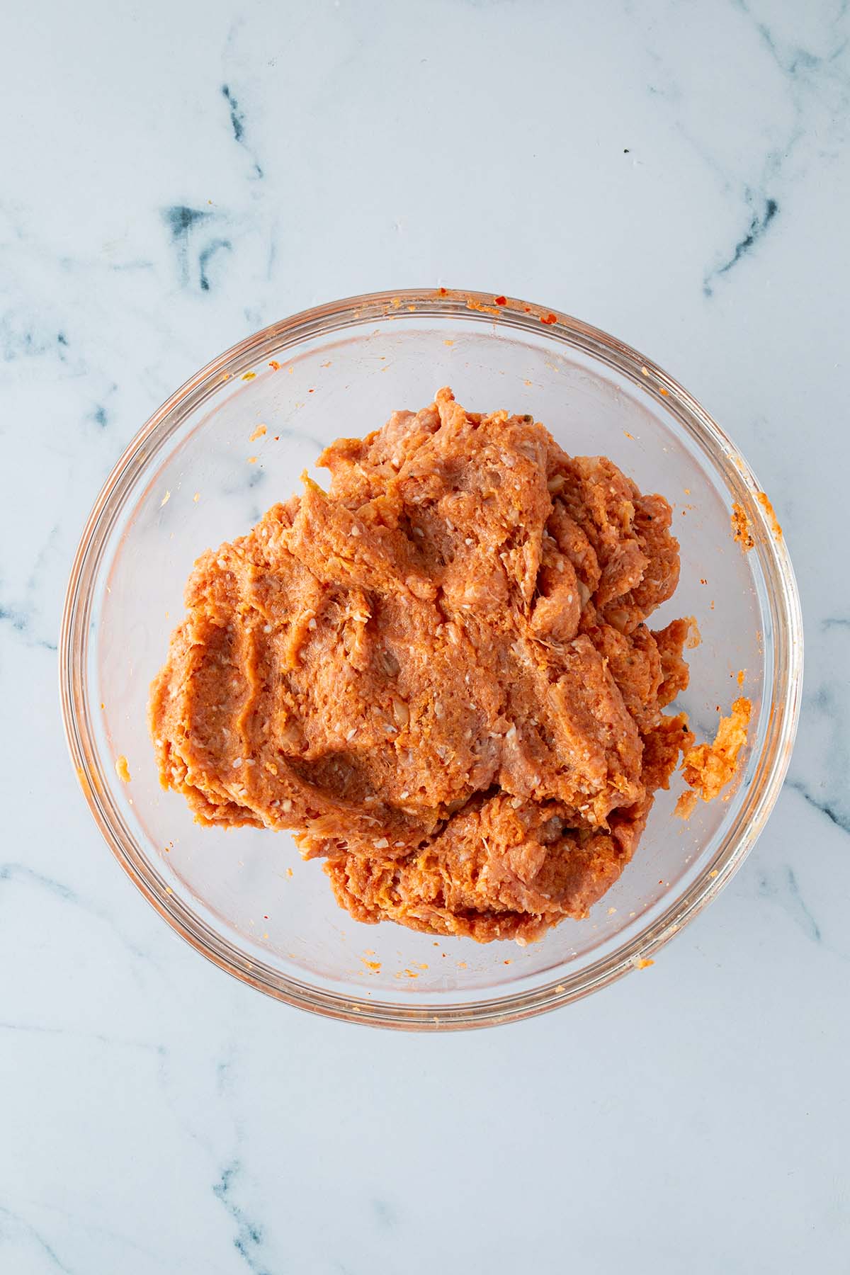 Verknetete Putenhackfleisch Kimchi Masse f&uuml;r die Burger Patties in einer Glassch&uuml;ssel.