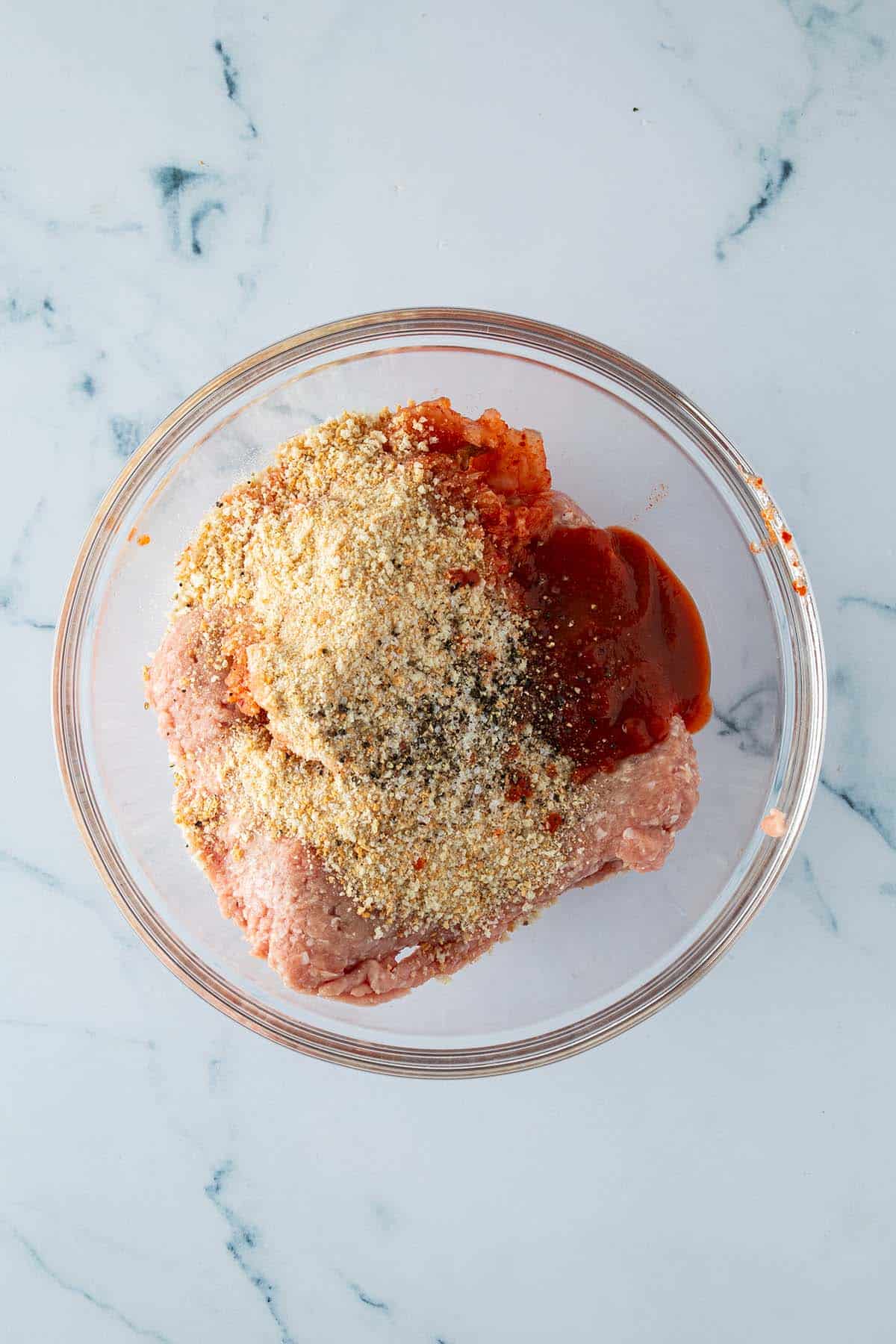 Putenhackfleisch, Semmelbr&ouml;sel, Sriracha und fein gehackter Kimchi in einer Glassch&uuml;ssel.