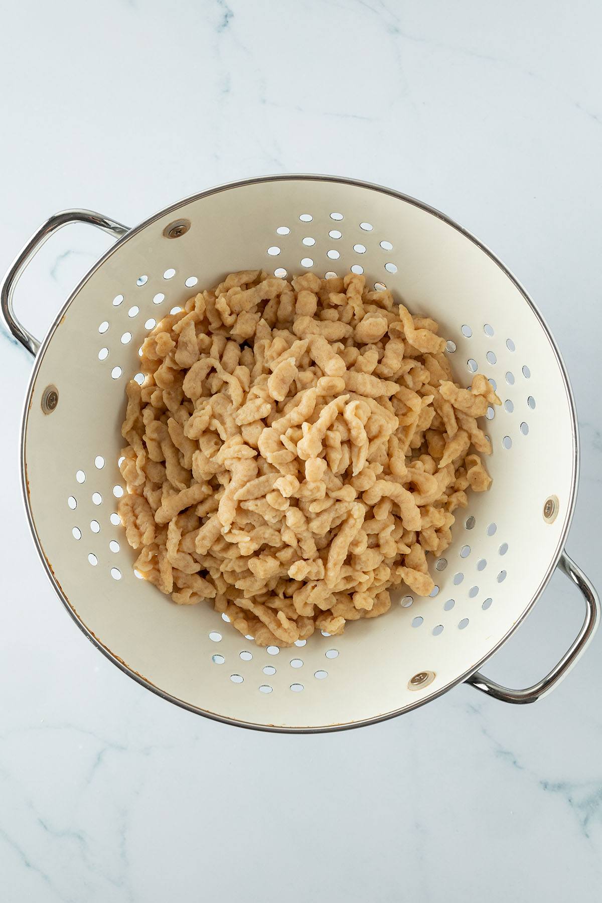 Fertige Sp&auml;tzle in einem wei&szlig;en Metall-Seiher.
