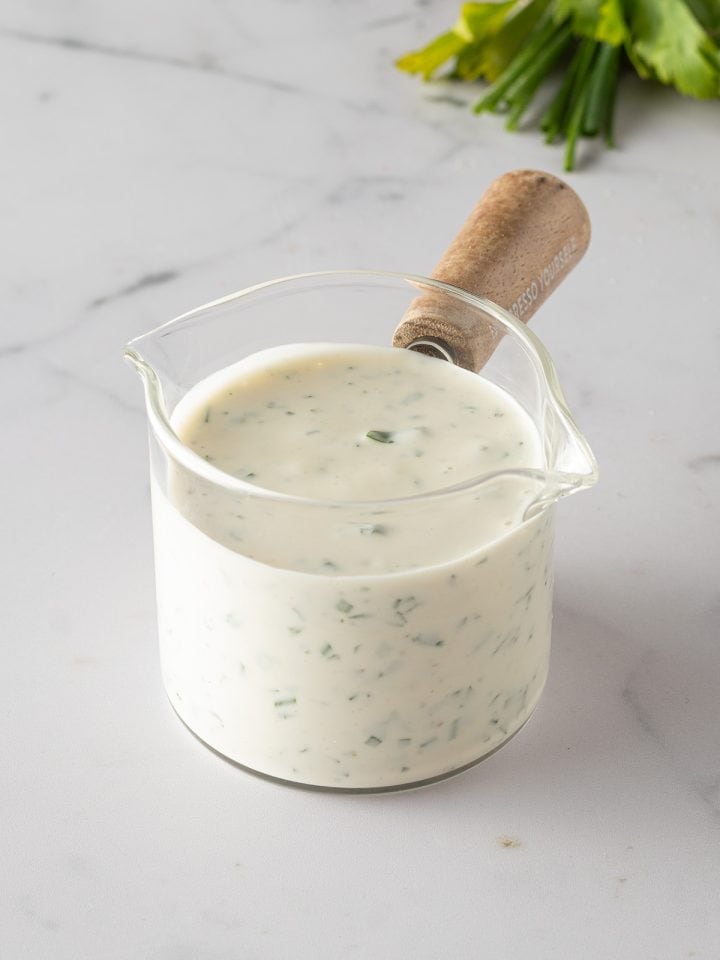 Cremiges selbstgemachtes Ranch Dressing mit frischen Kr&auml;utern in einem kleinen Glasgef&auml;&szlig;.