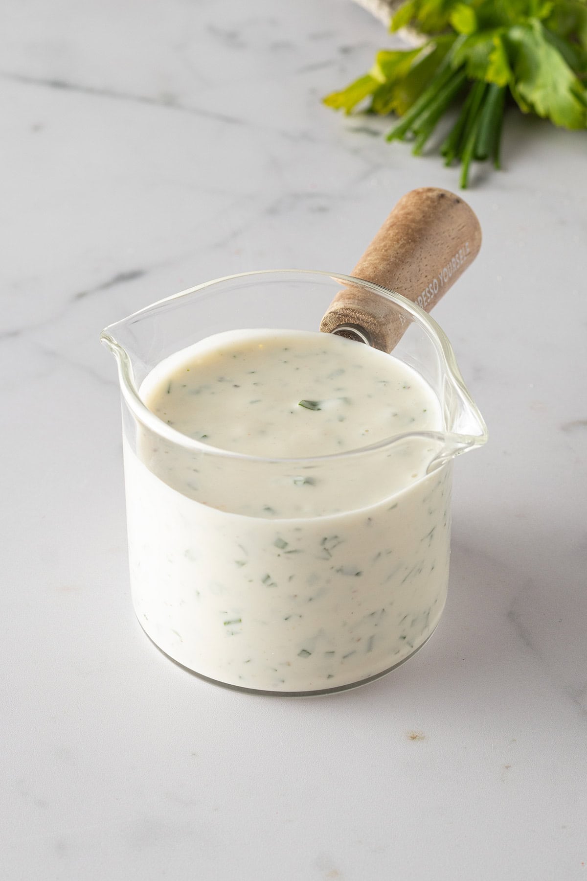 Cremiges selbstgemachtes Ranch Dressing mit frischen Kr&auml;utern in einem kleinen Glasgef&auml;&szlig;.