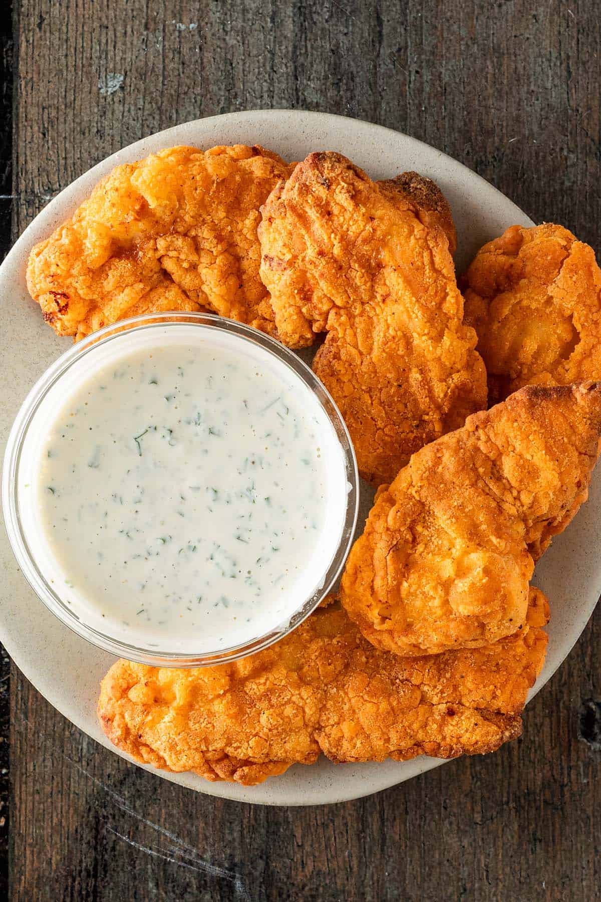 Knuspriges Fried Chicken mit cremigem Ranch Dip auf einem Teller.