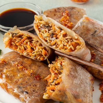 Ein Teller mit Reispapier Dumplings und zwei Dips.