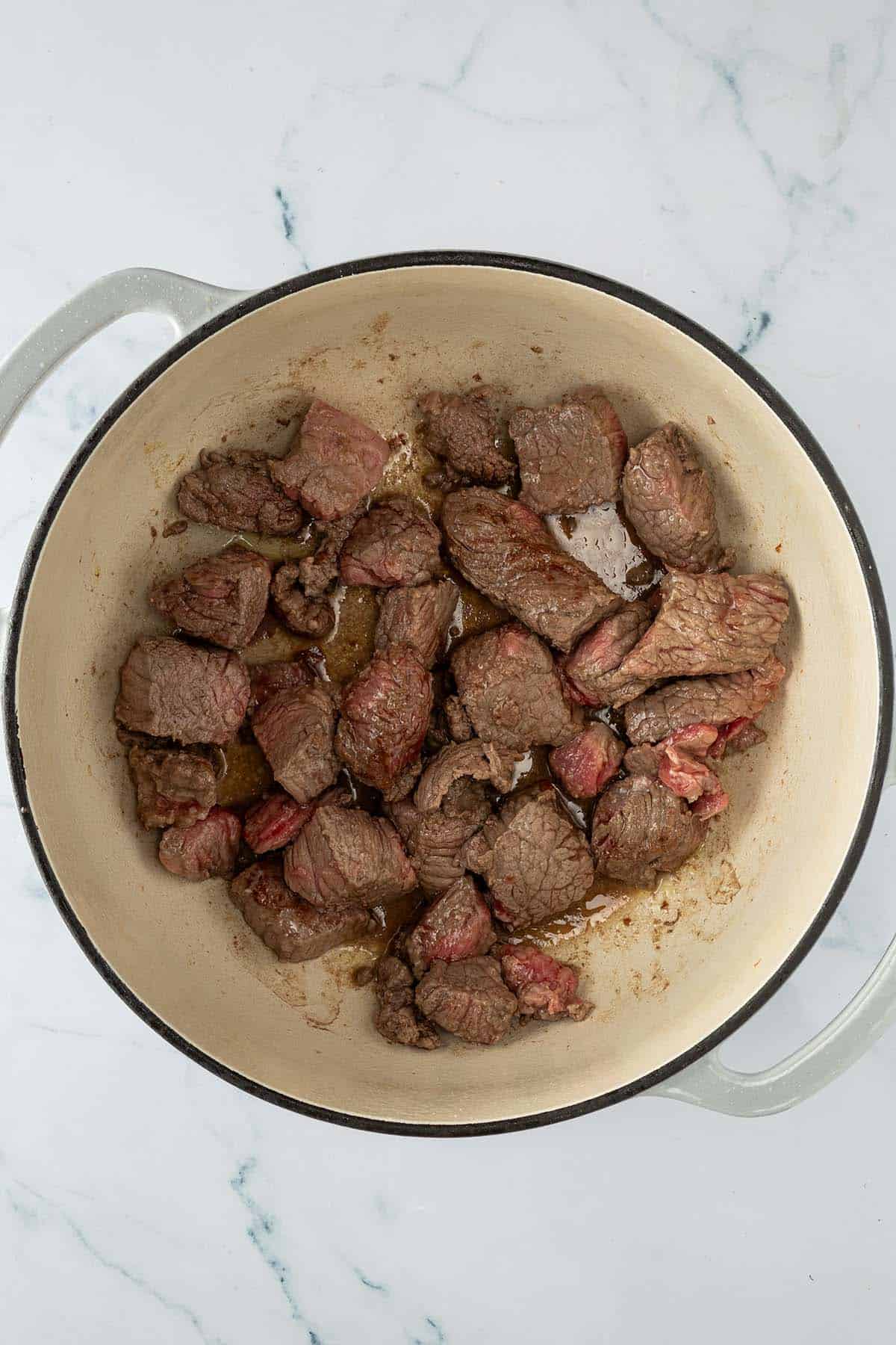 Kurz angebratenes Rindfleisch in einem gro&szlig;en Topf.