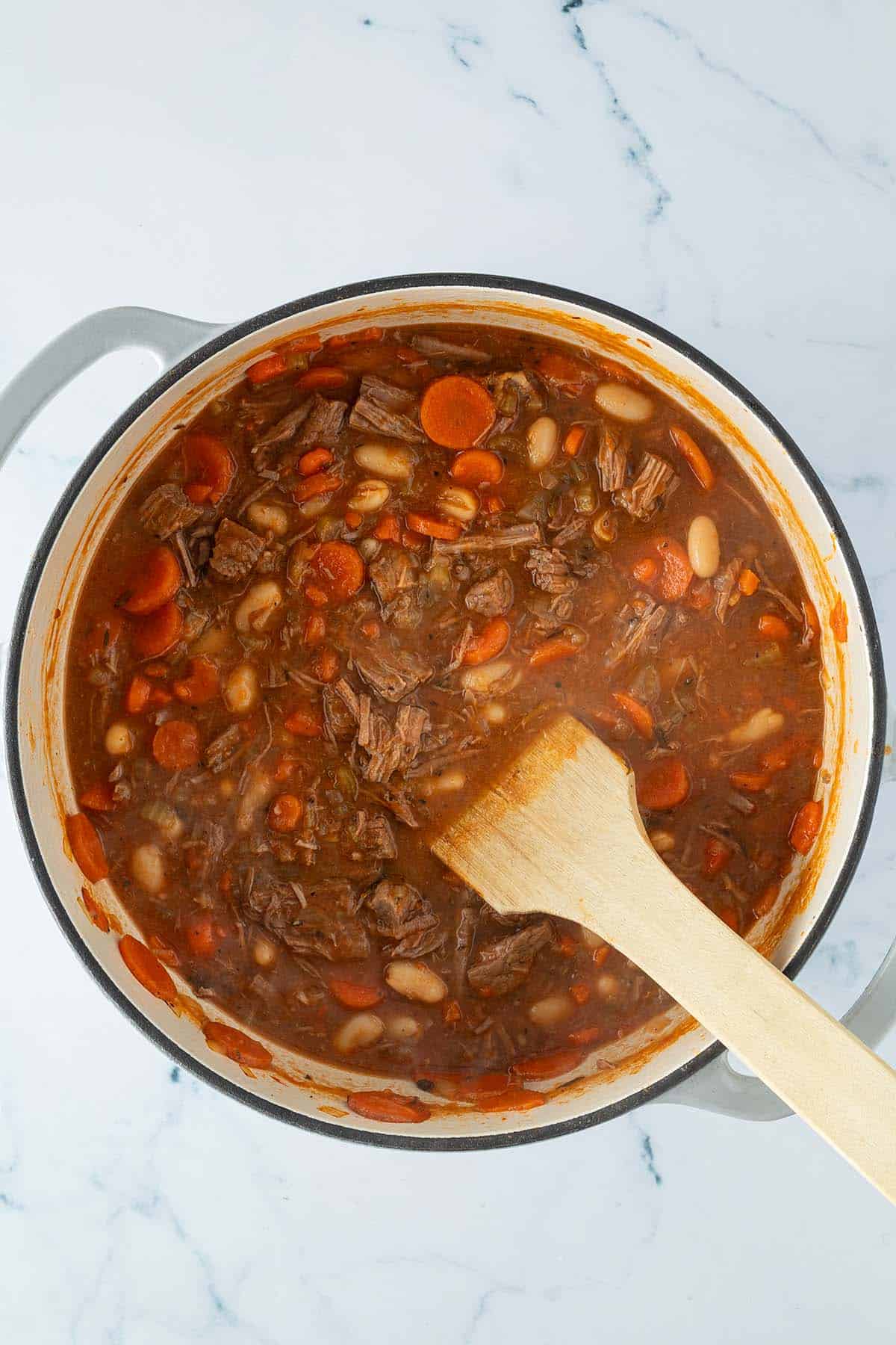 Fertig gegarter Rindfleischeintopf mit einer s&auml;migen Sauce, zerfallenem Rindfleisch und Karotten in einem gro&szlig;en Topf.