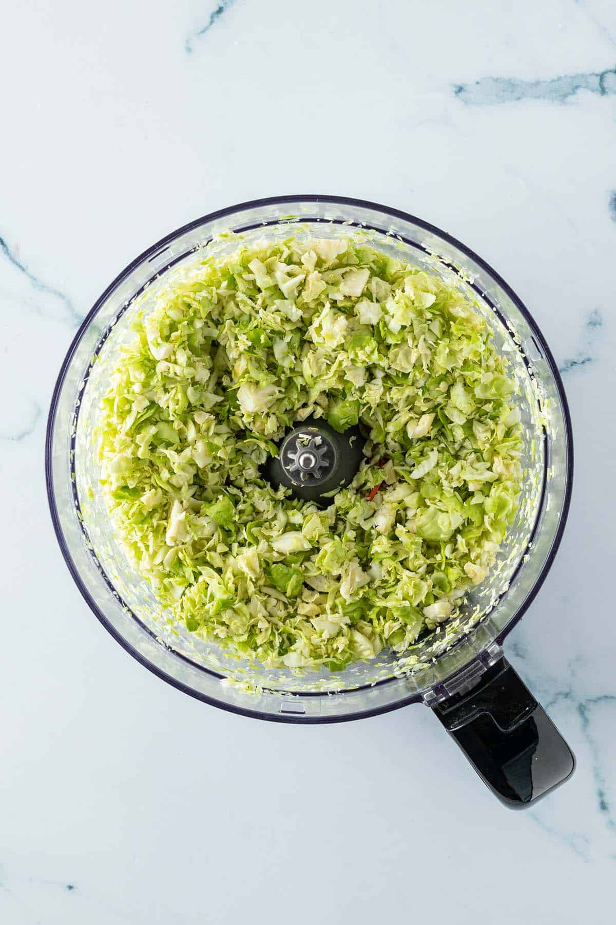 Fein zerkleinerter Rosenkohl in einer K&uuml;chenmaschine.