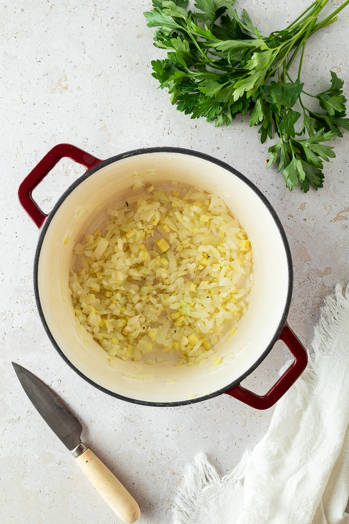 Zwiebeln, Knoblauch und Ingwer werden in einem Topf angebraten.