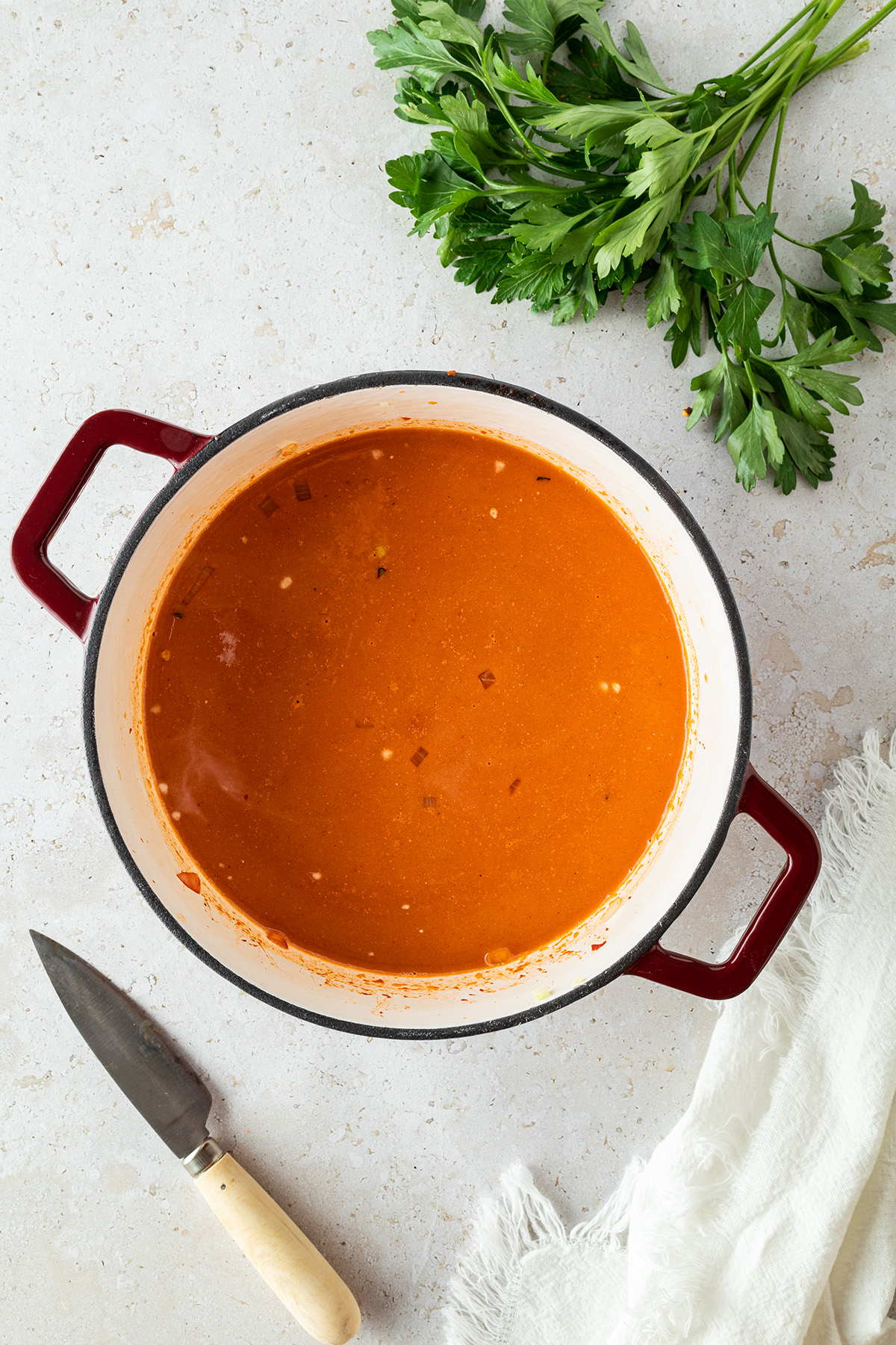 Der Zubereitungsschritt zeigt einen Topf mit einer fl&uuml;ssigen roten Suppe drin.