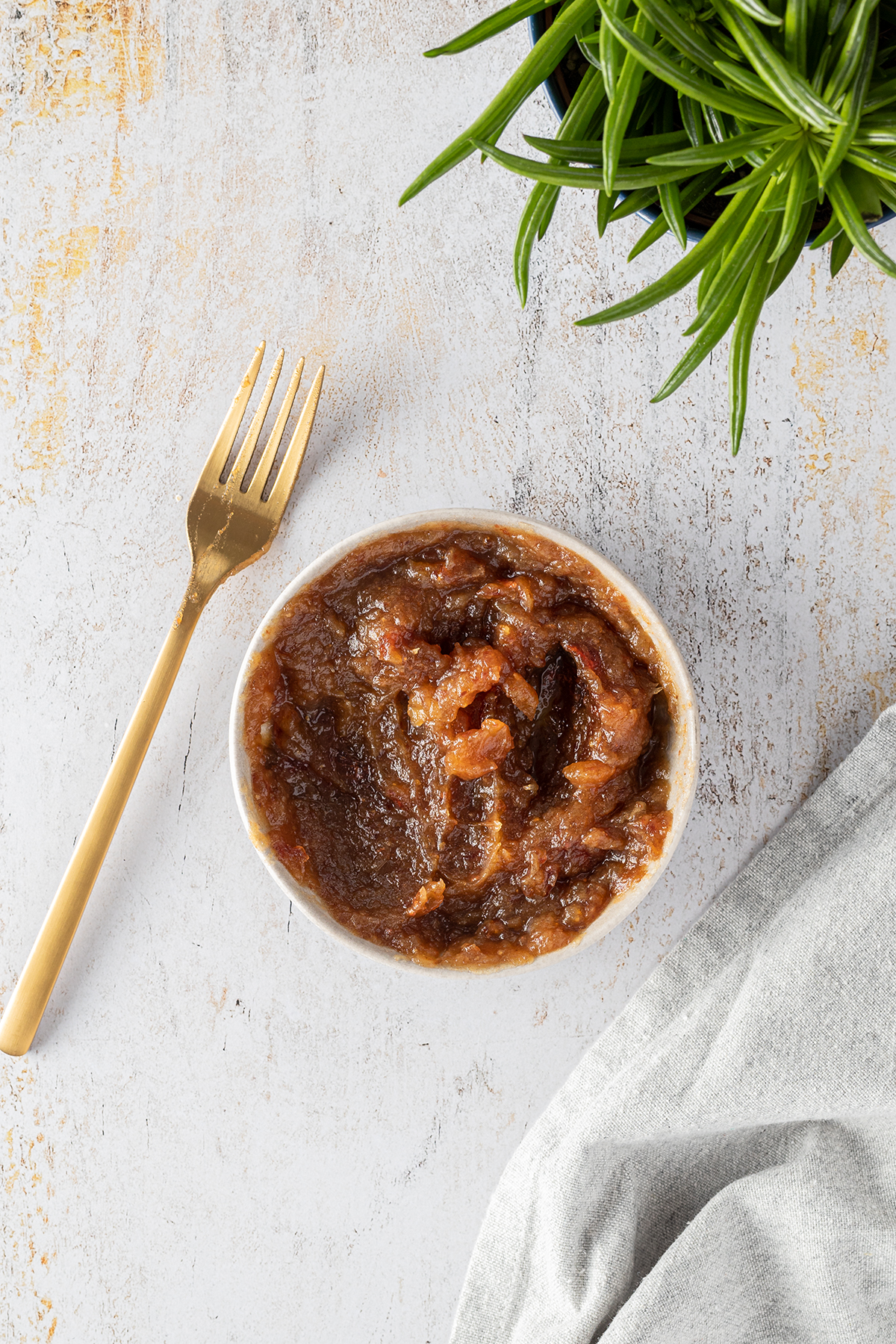 eine Sch&uuml;ssel mit selbst hergestellten Dattelp&uuml;ree, daneben eine goldene Gabel.