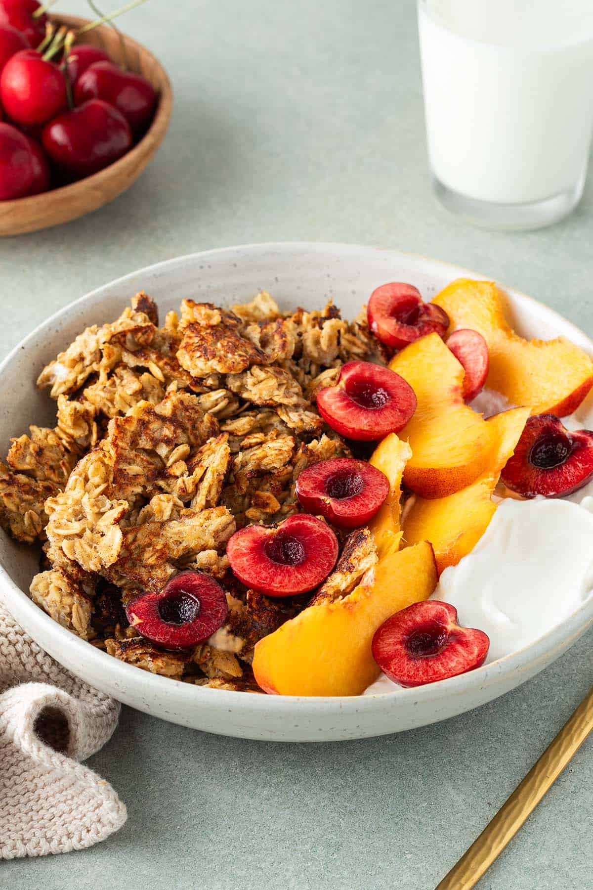 Scrambled Oats in einem Teller mit frischem Obst und Joghurt, Deko im Bildrand.